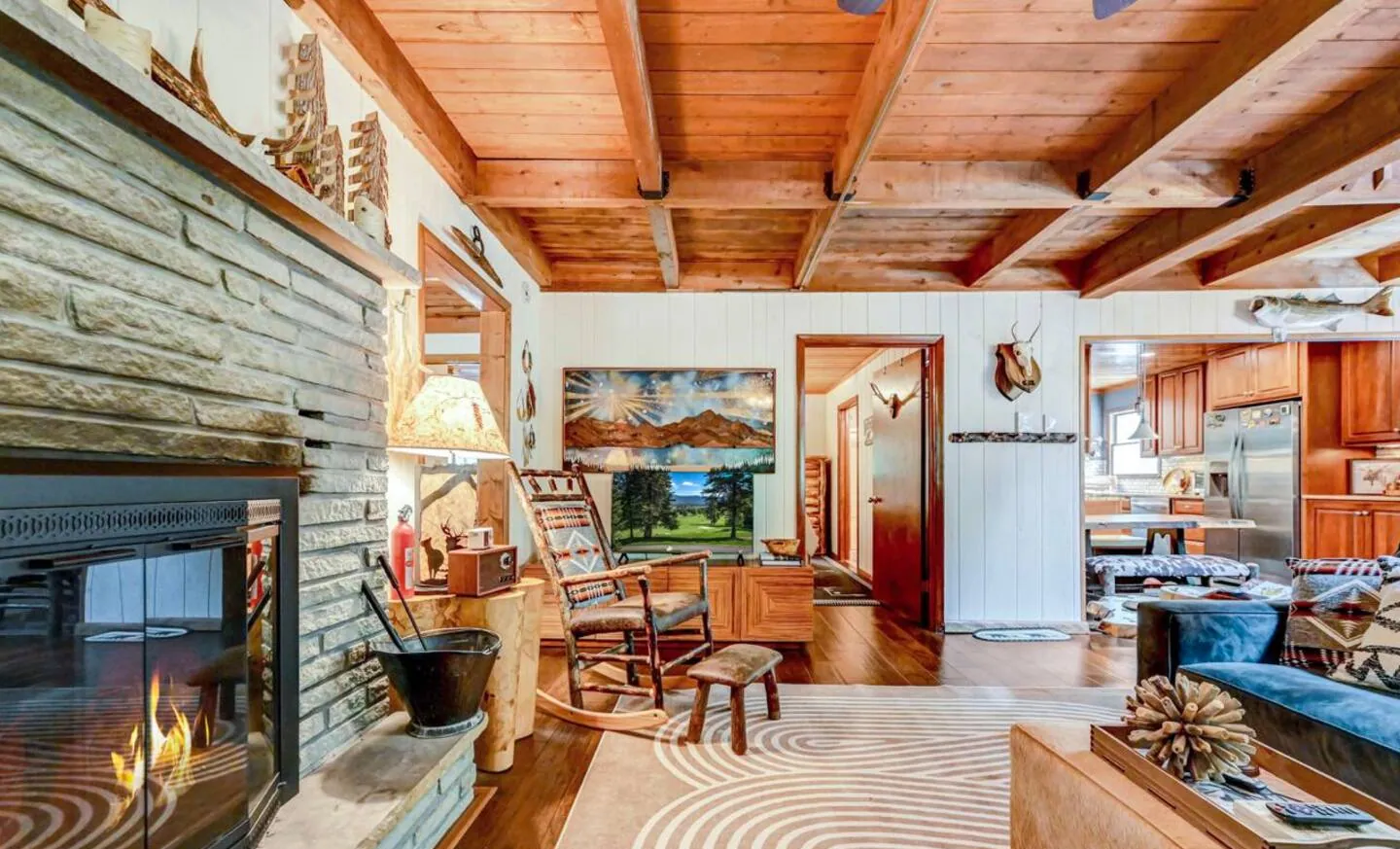 Two-sided fireplace with barnwood wall and view to the kitchen at Mountain MAMA