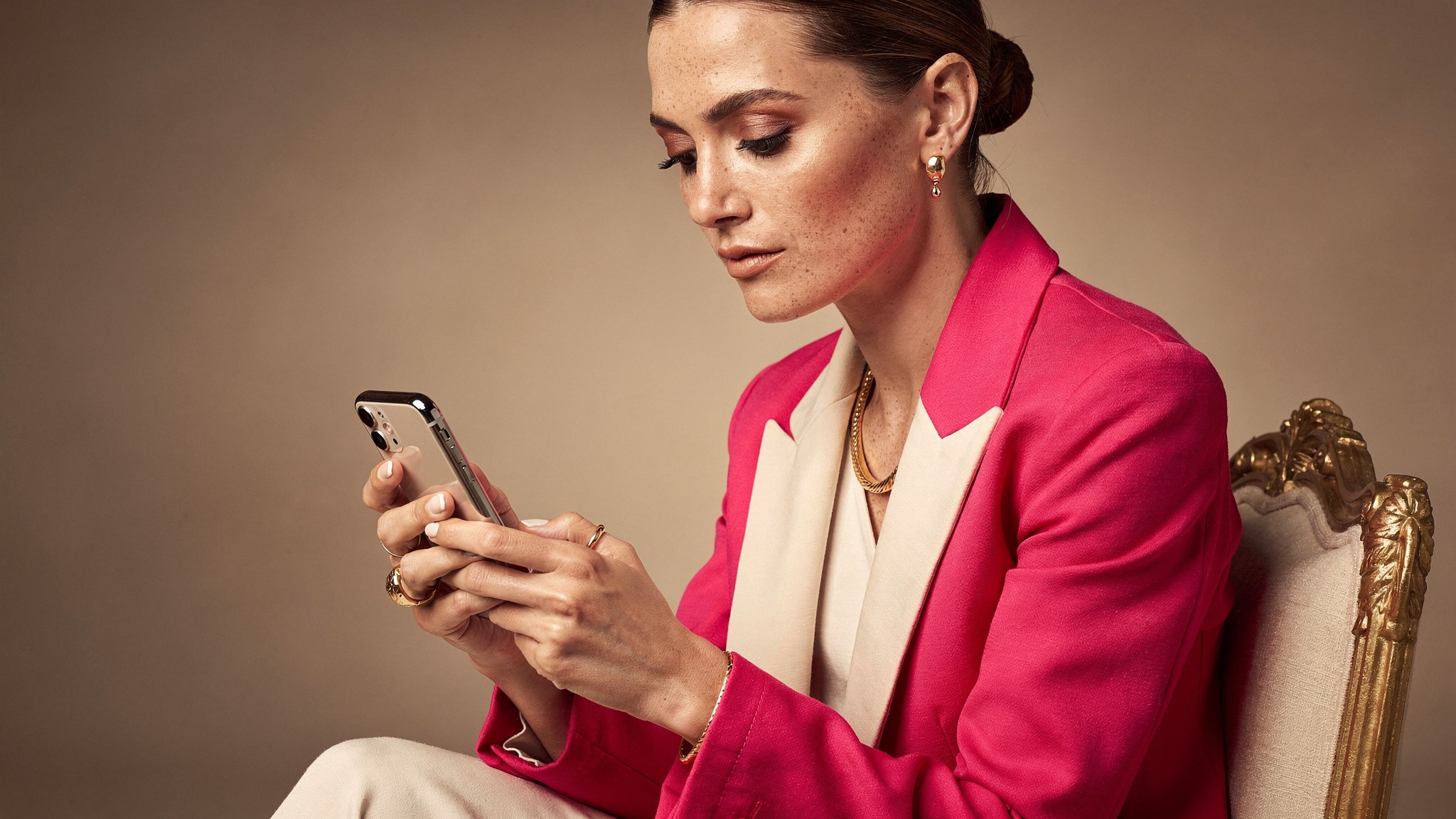 Creator typing a caption on her phone with a focused creative expression