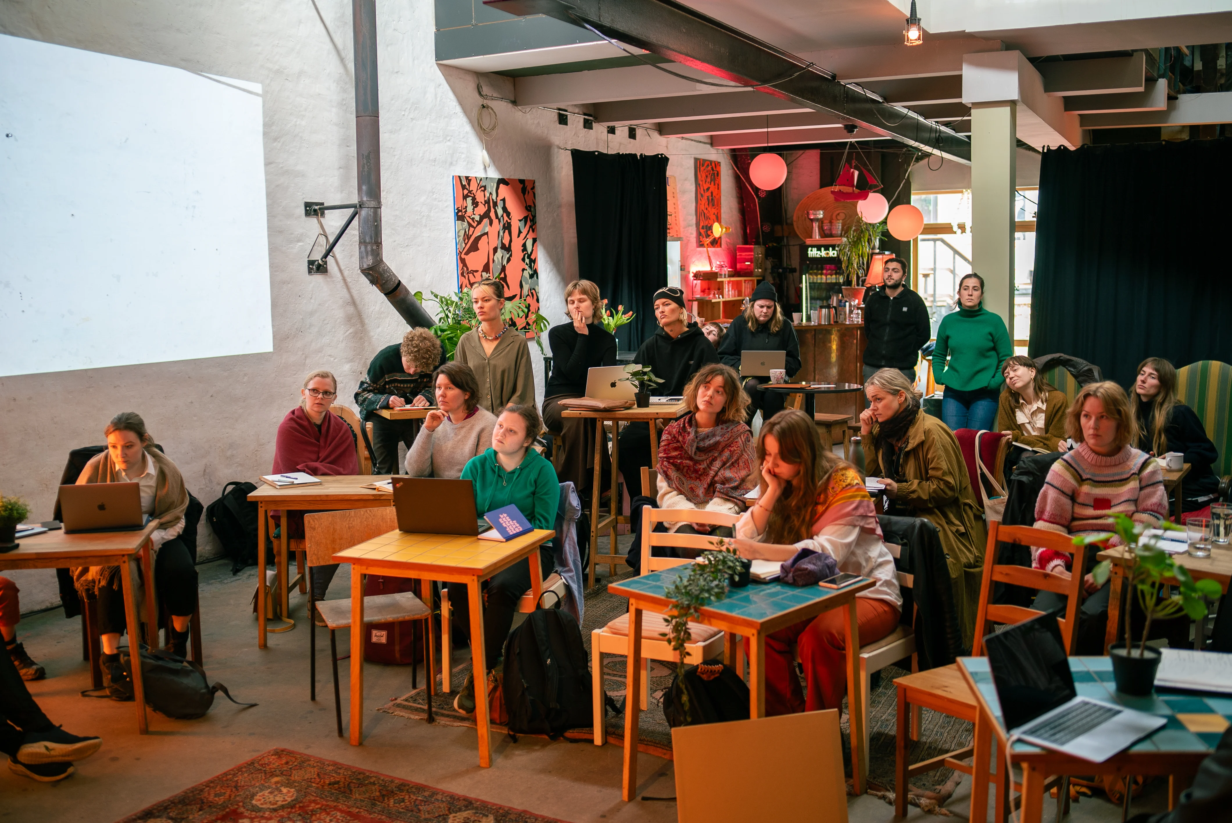 Et hold af kulturskabere sidder og lytter på stole.