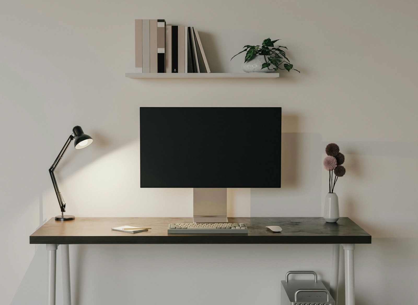 a desk with a computer monitor and a lamp