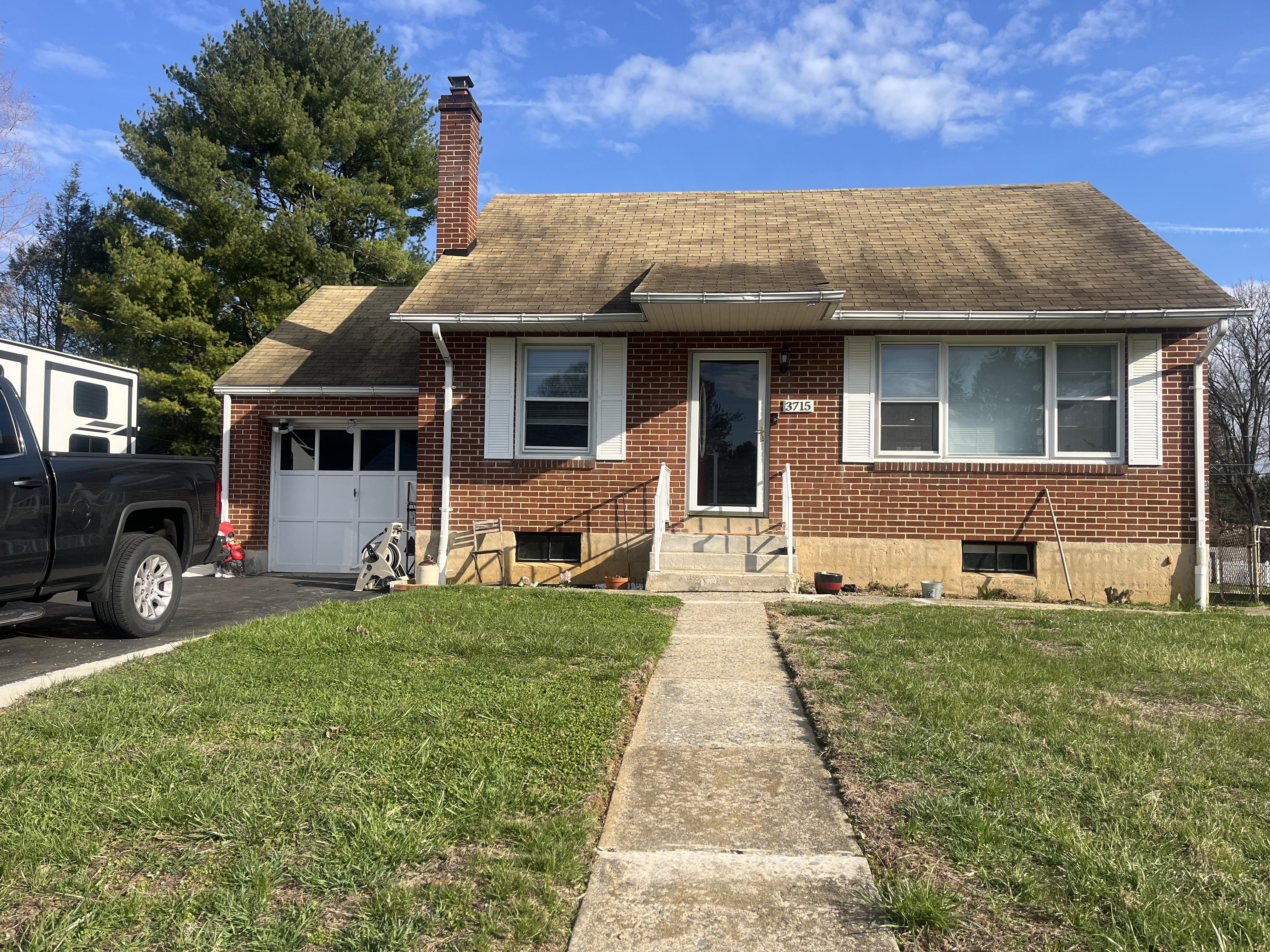 The original brick ranch — dated roof, plain walkway, minimal landscaping