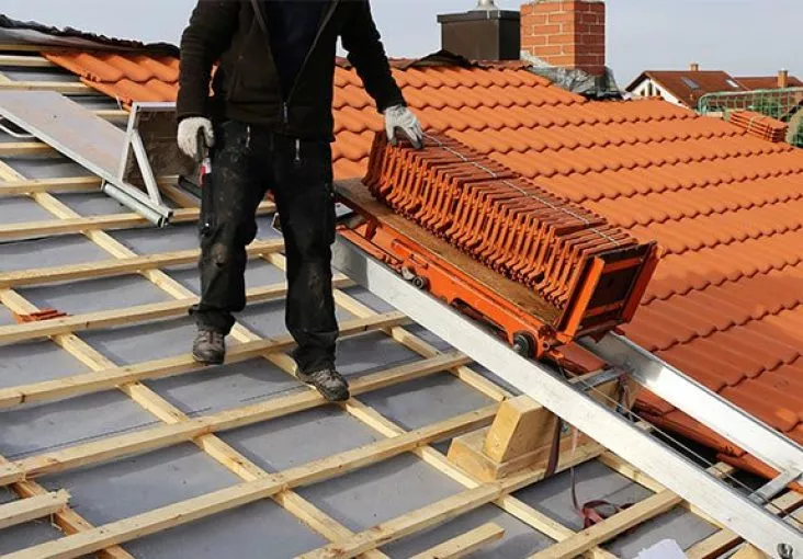 Couvreur sur un toit en plein chantier de couverture