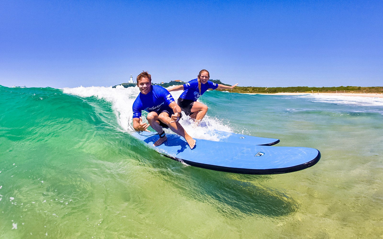 Surfisti che cavalcano un'onda durante una lezione a Maroubra Beach, Sydney.