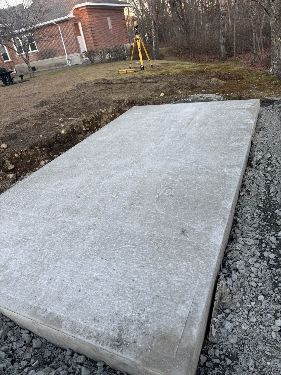 Concrete equipment pad poured beside a lawn, by A&M Construction Enterprises