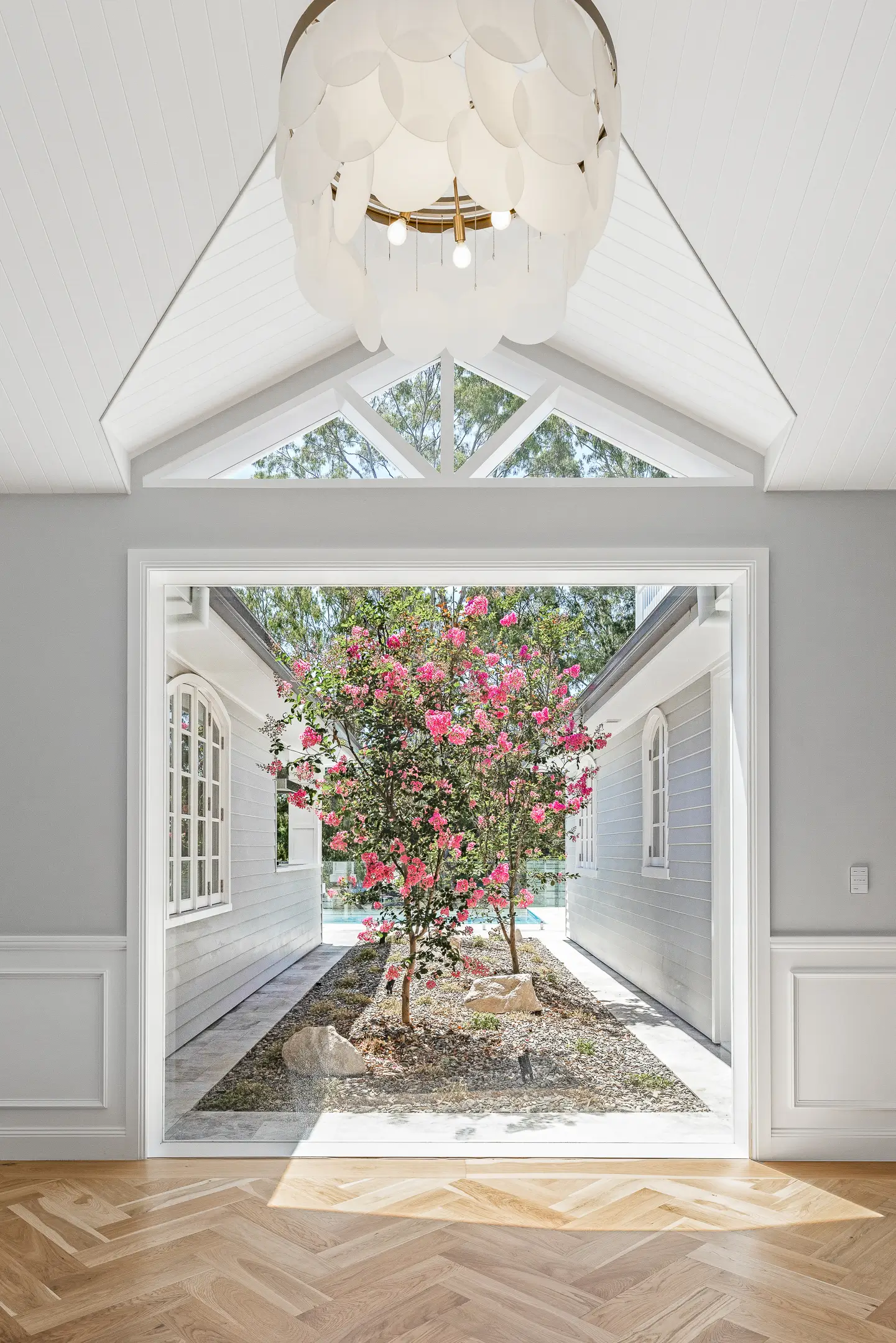 The picture window upon entry with a view of a Jacaranda tree