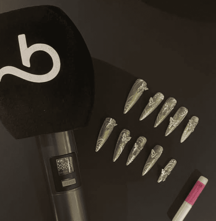 photo of a set of nails on a black table and a booksy microphone