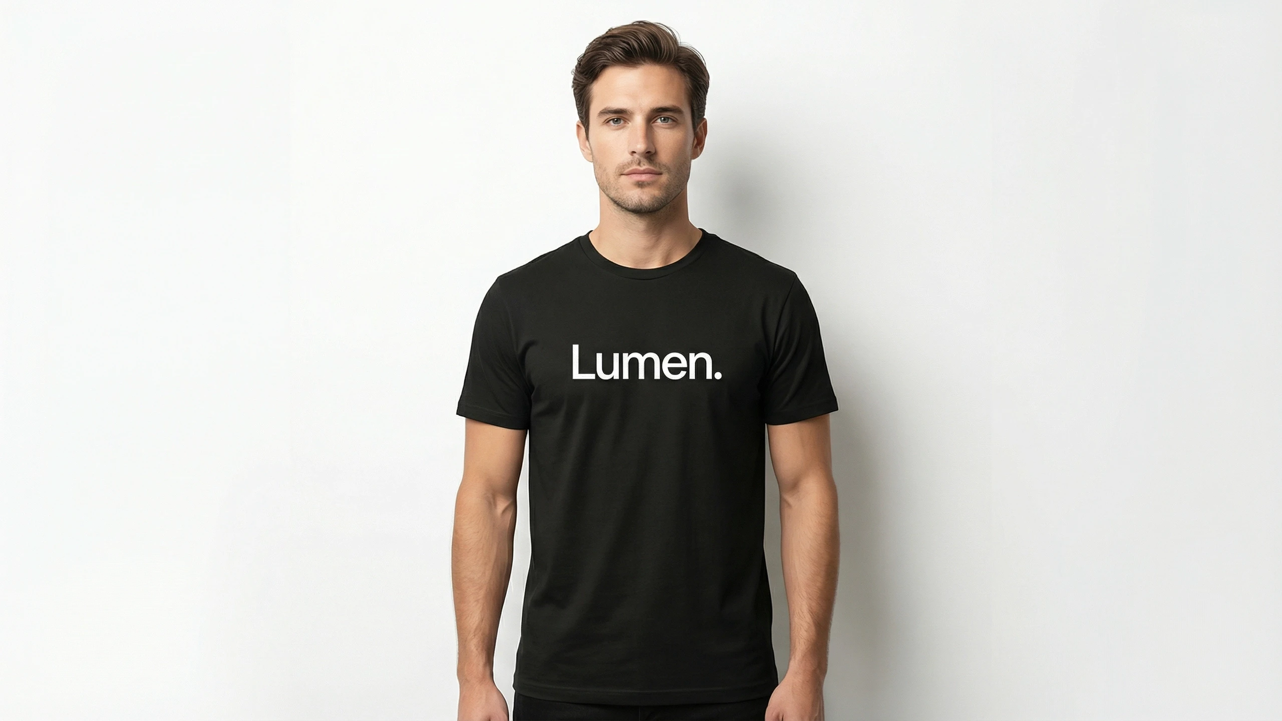 Man wearing a premium black crew neck t-shirt featuring the white 'Lumen.' logo on the chest, isolated on a clean white background.