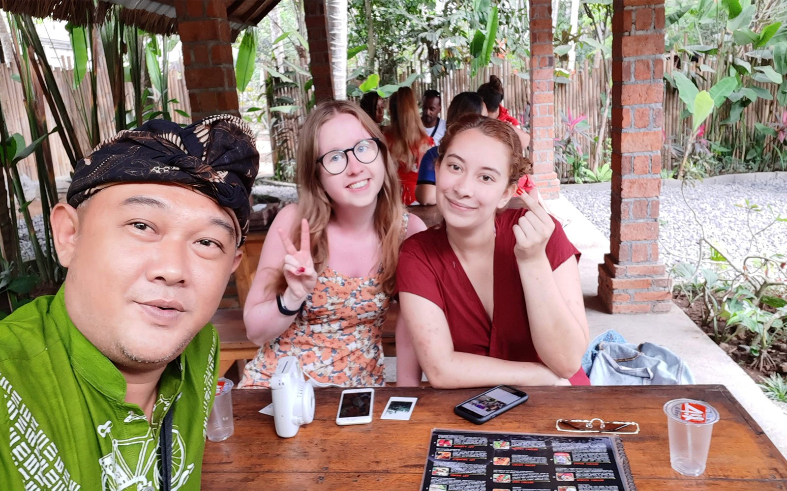 Группа наслаждается обедом в ресторане на Бали во время частной экскурсии на автомобиле.