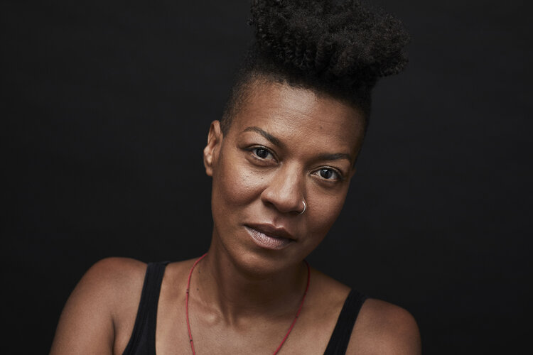 man in black suit jacket holding white ceramic mug