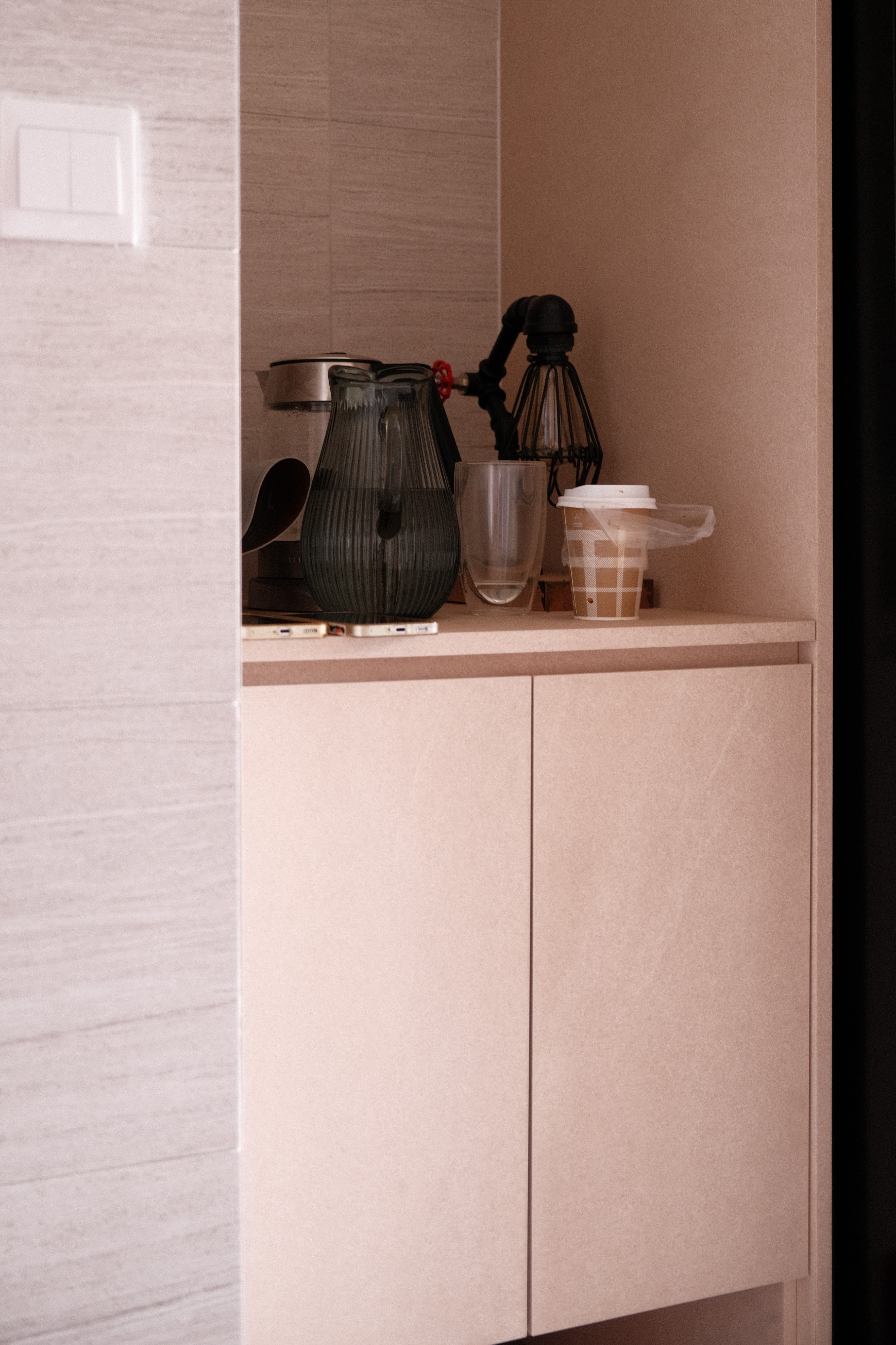 Modern bathroom with deep green tiles, terracotta flooring, and white sanitary ware, featuring a bidet spray and large window for natural light.
