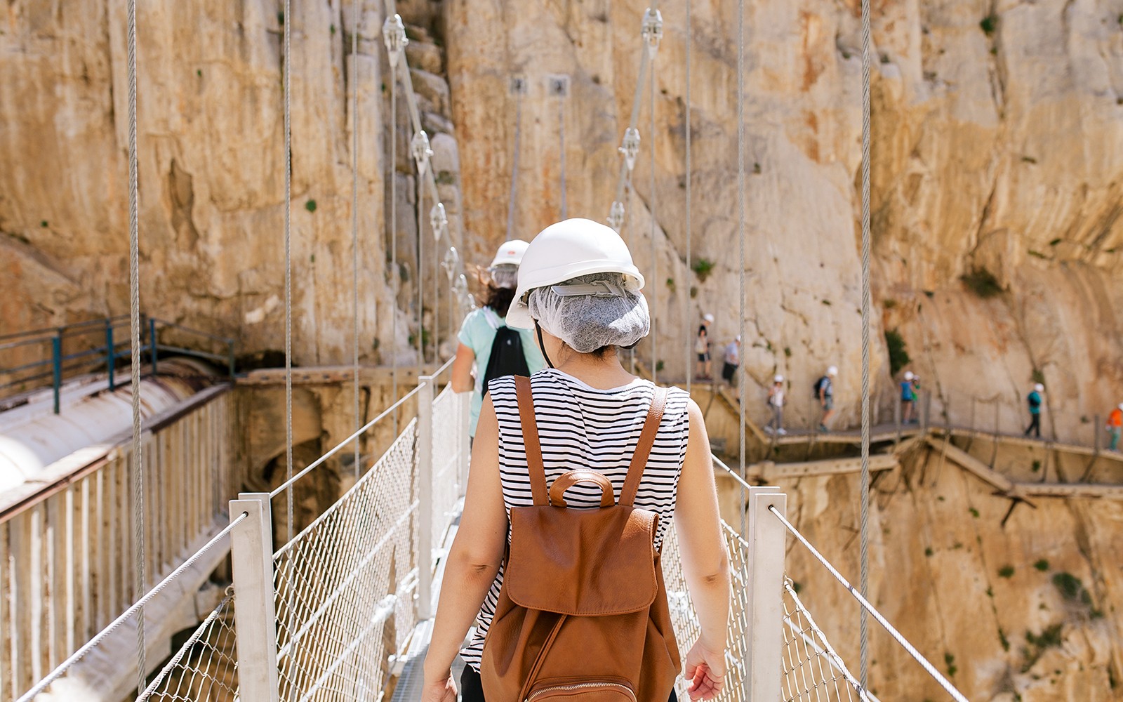 Visitors crossing a narrow bridge on the Caminito del Rey guided tour in Spain.