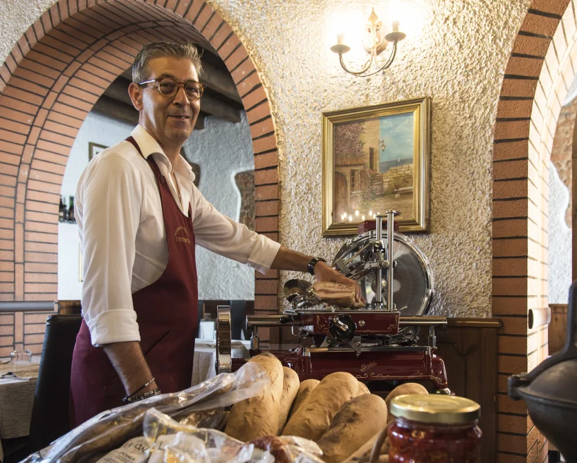 Portrait of the head chef standing at the restaurant entrance.