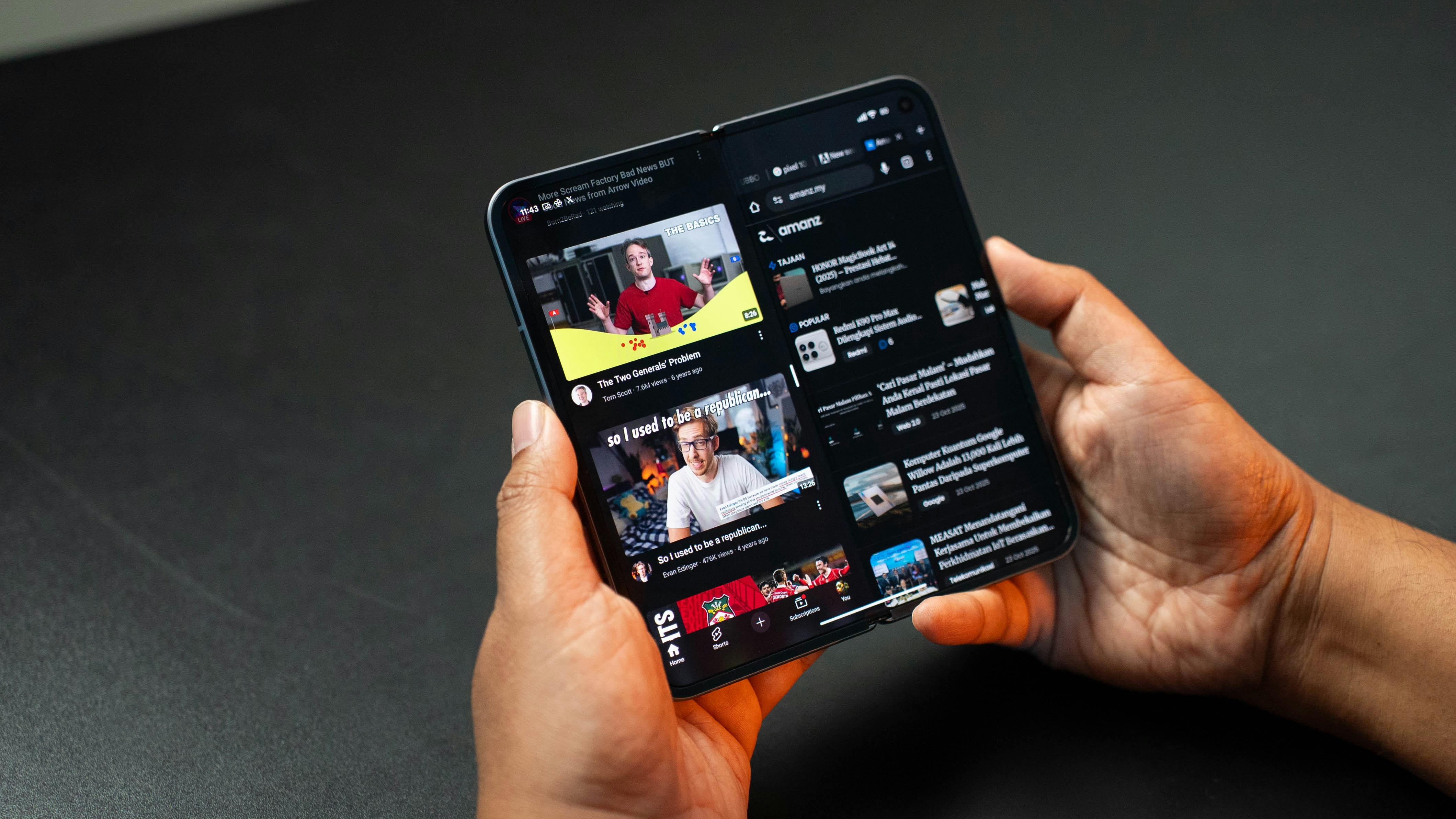 Hands holding a folding smartphone displaying youtube