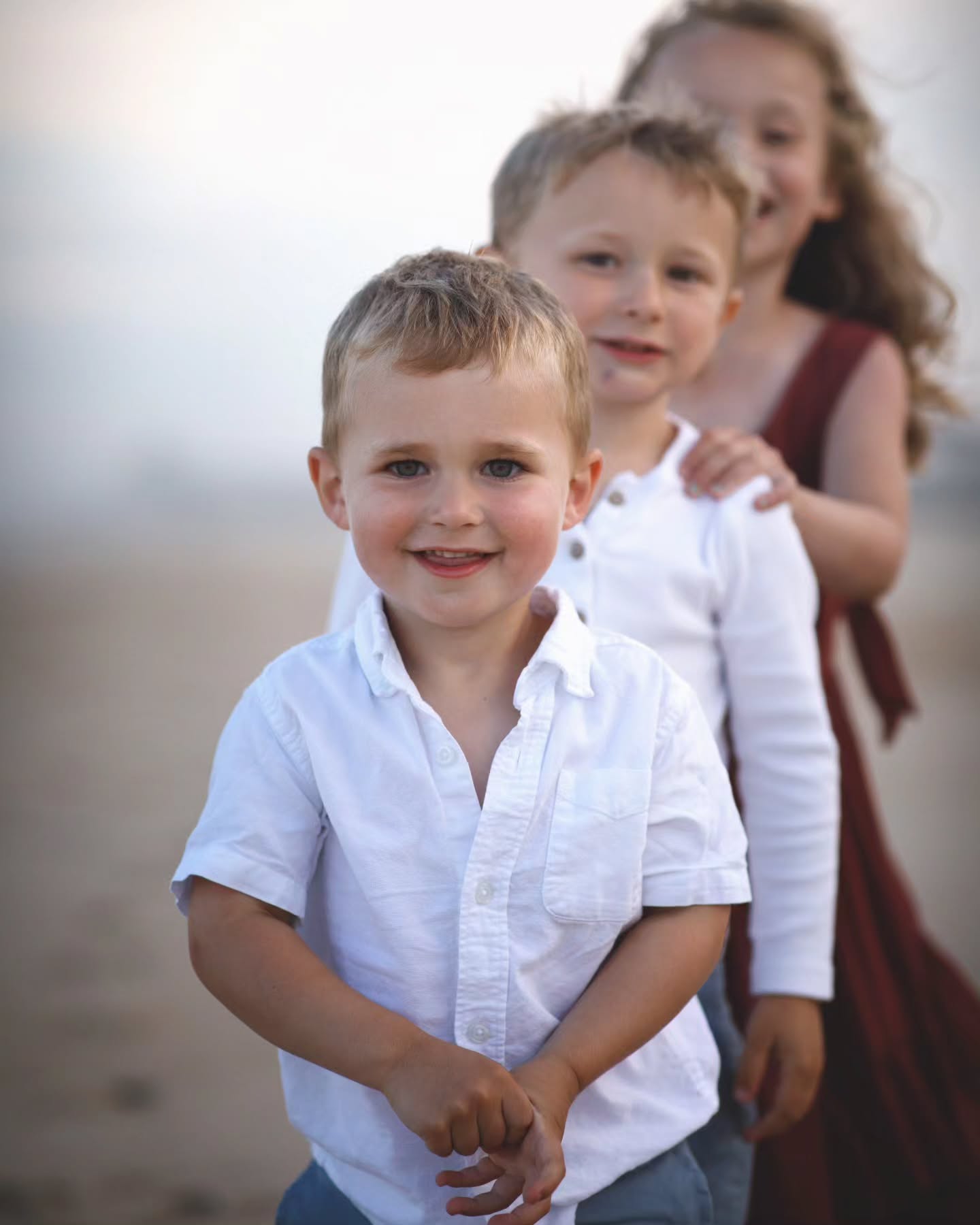 Smiling young boy in a white shirt during a relaxed lifestyle photoshoot.