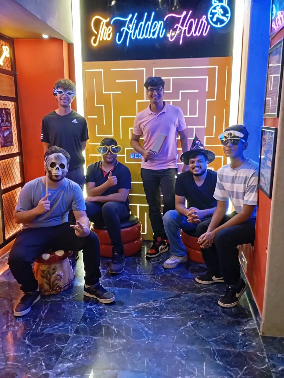 Excited players posing with “We Escaped!” sign at Hidden Hour Gurugram