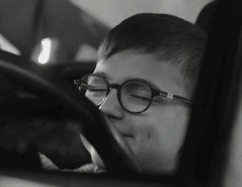 A boy imagining himself driving a car