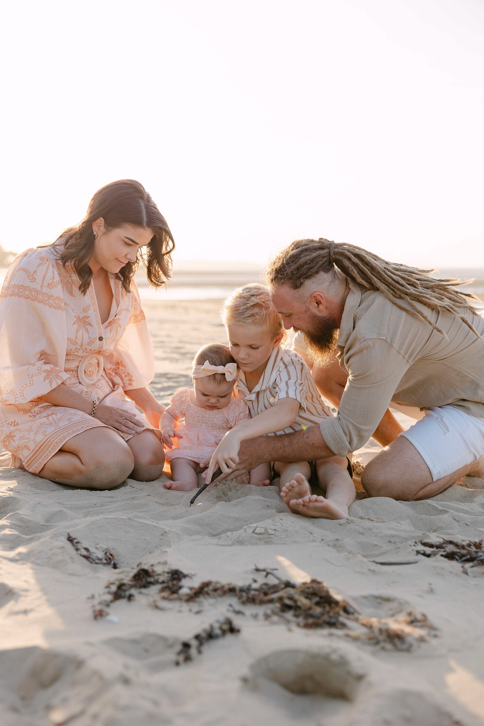 Parents and children playing in the sand at Mackay Beach