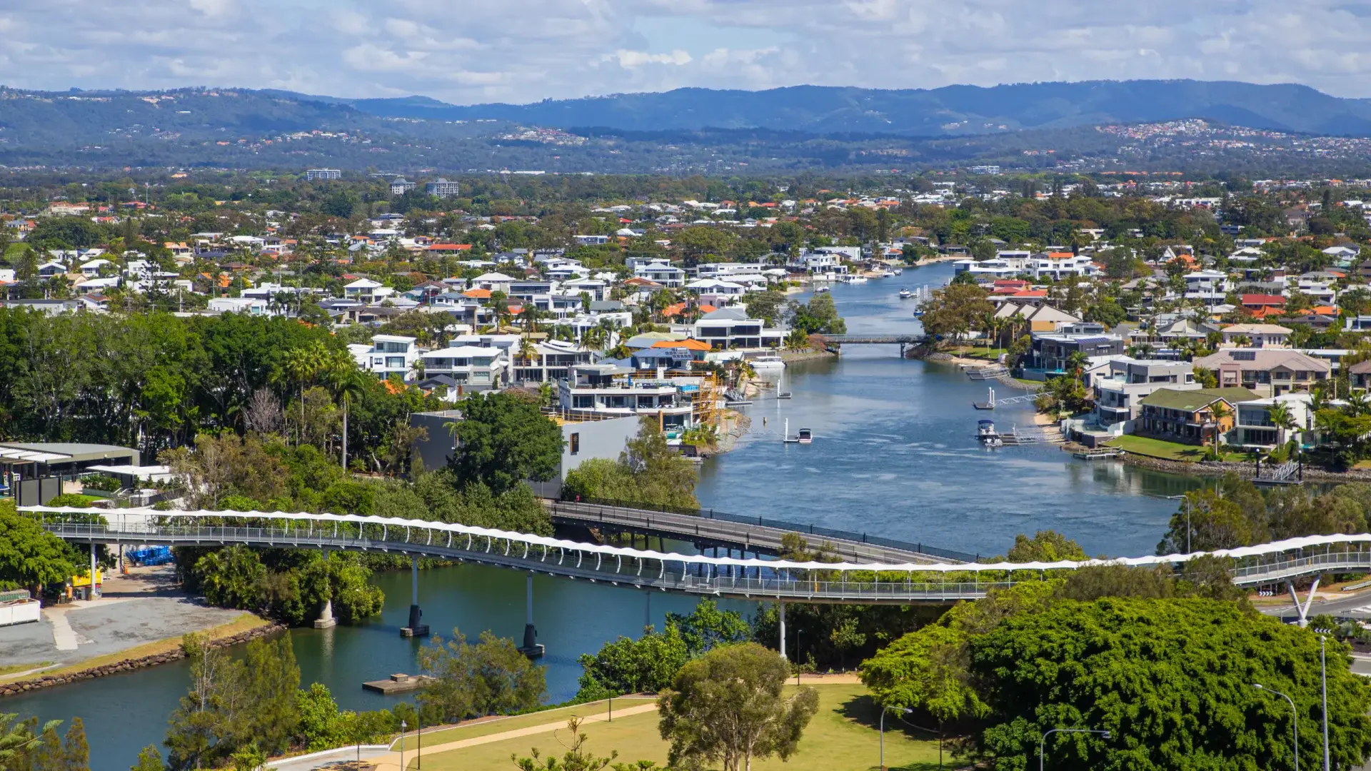 Waterfront homes and bridges with mountains in the distance.