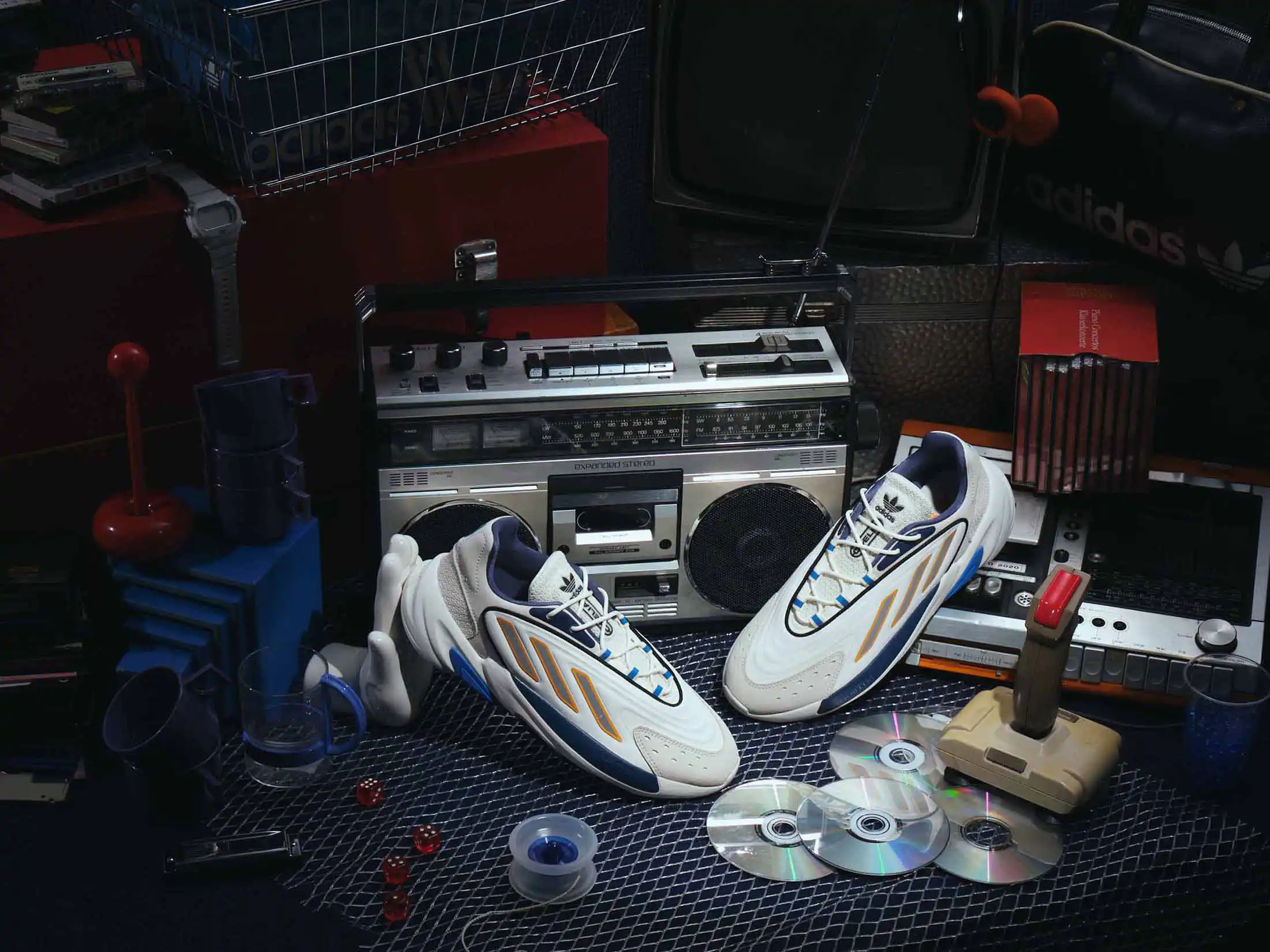 Vintage Adidas sneakers framed by a retro boombox, cassette tapes and vintage pin badges.
