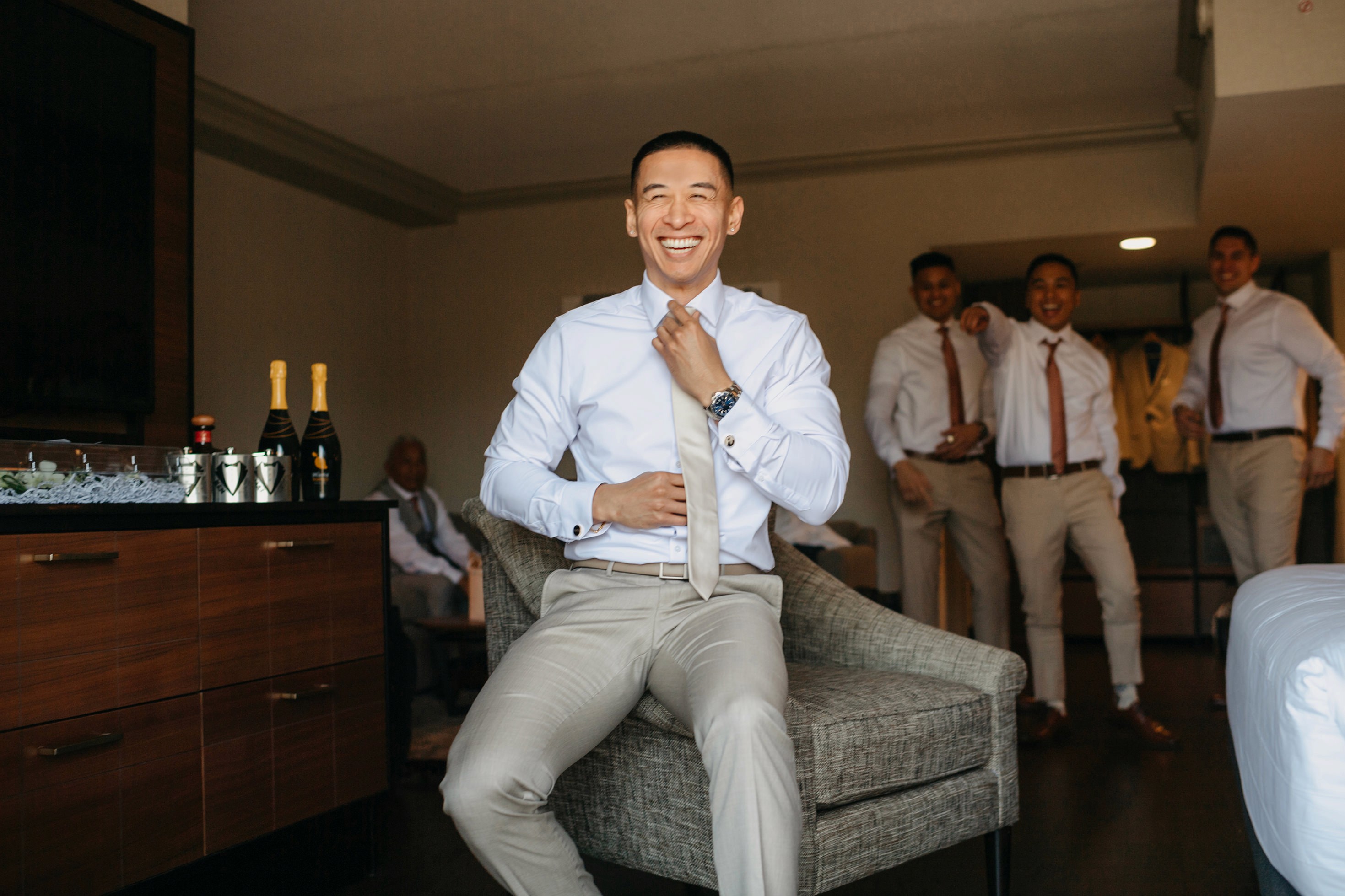 Groom adjusting tie during getting ready photos