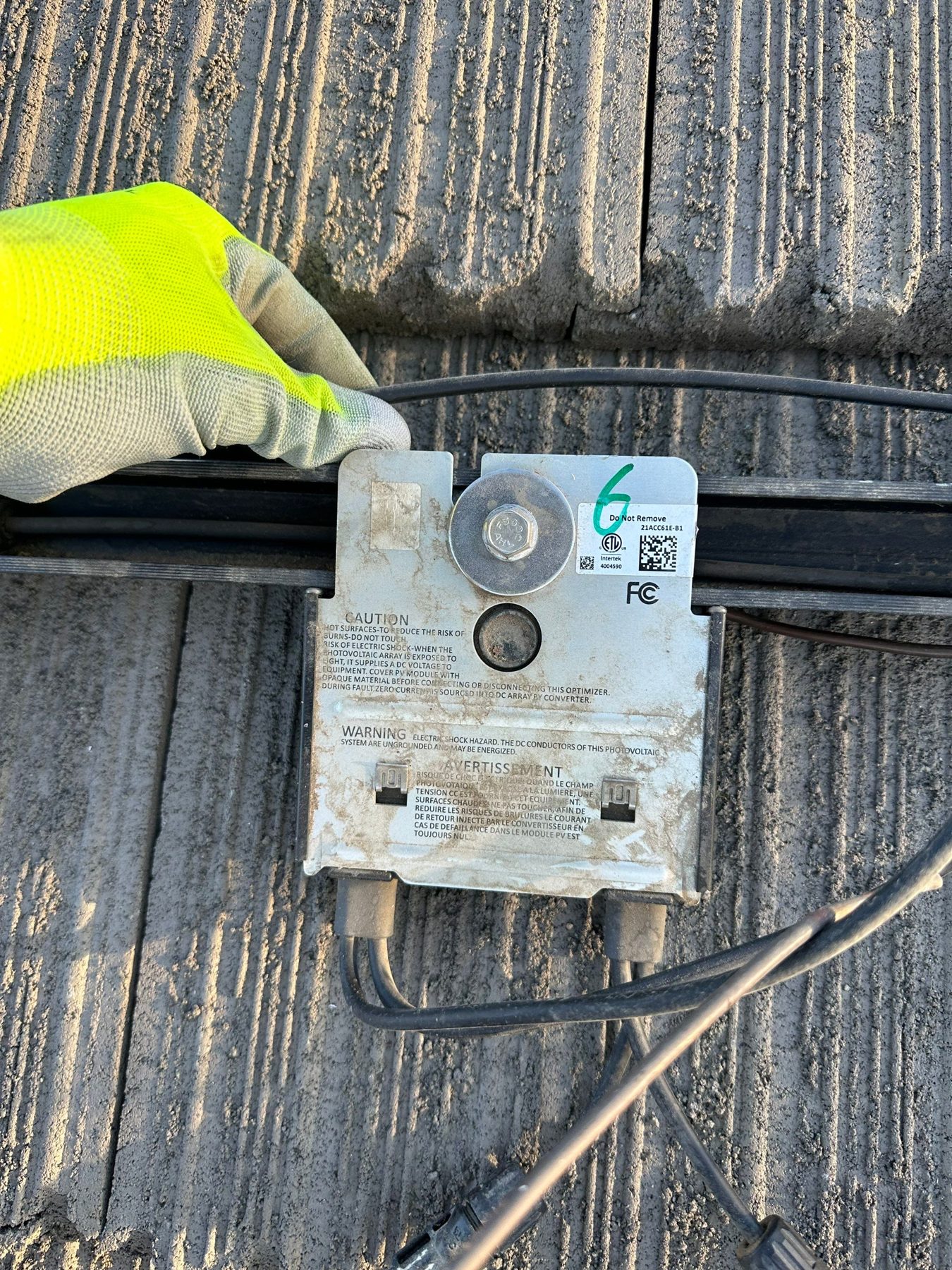 Technician servicing a rooftop microinverter