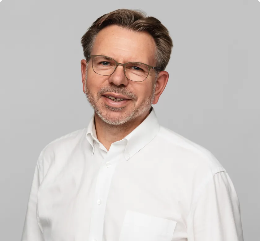 Gerald Rosak, Dyrektor ds. przychodów w digna, noszący okulary i granatową marynarkę, reprezentujący przywództwo w strategii rynkowej i międzynarodowym rozwoju biznesu.