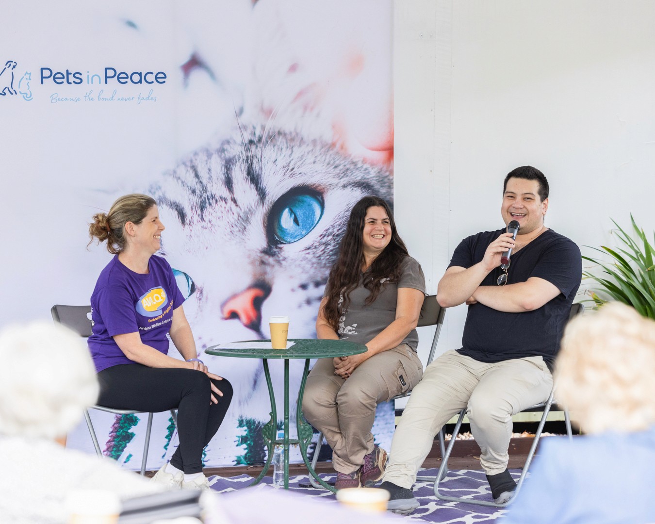 Three people laughing on stage
