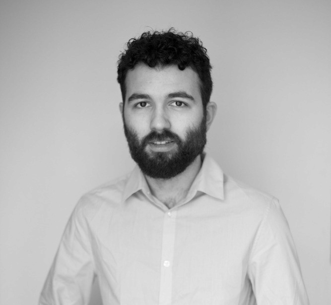 Black and white portrait of a smiling person with curly hair