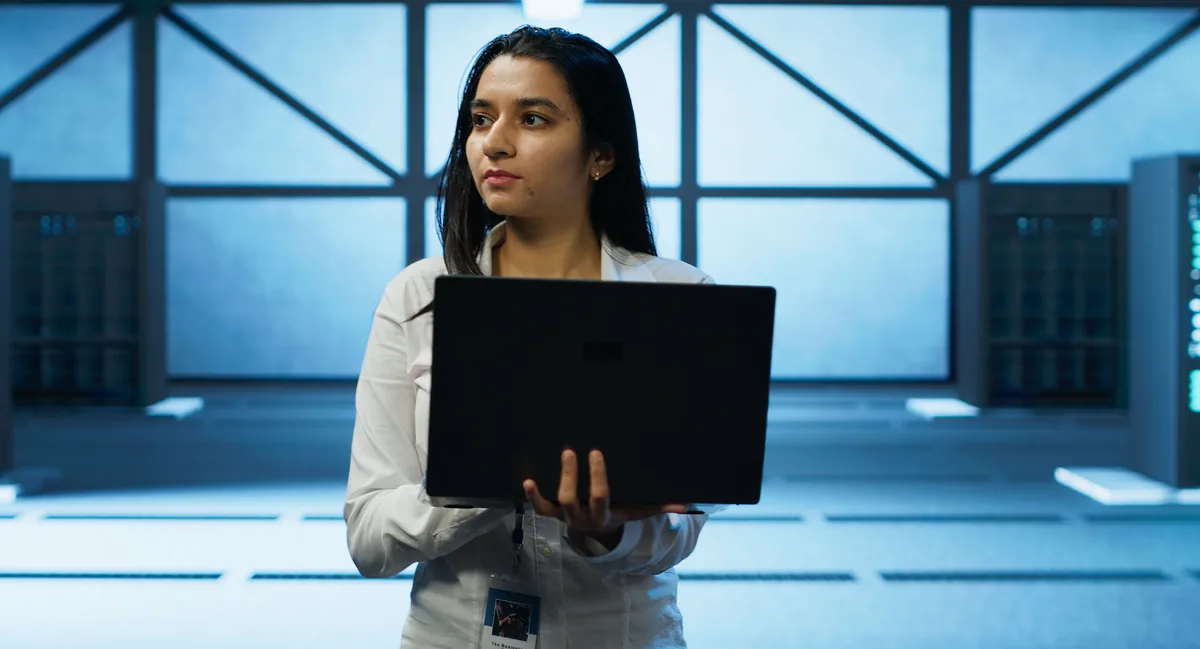 Cloud engineer holding a laptop inside a data center