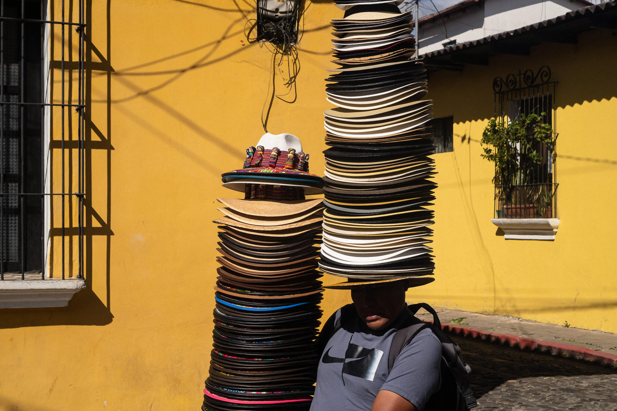 A man walking with many hats on his head