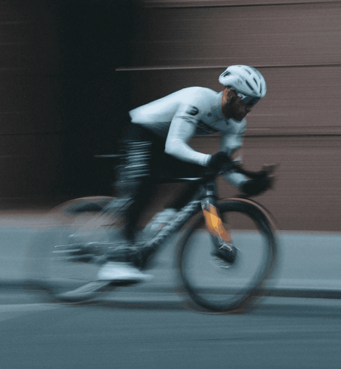 Cyclist riding fast with motion blur representing speed and performance