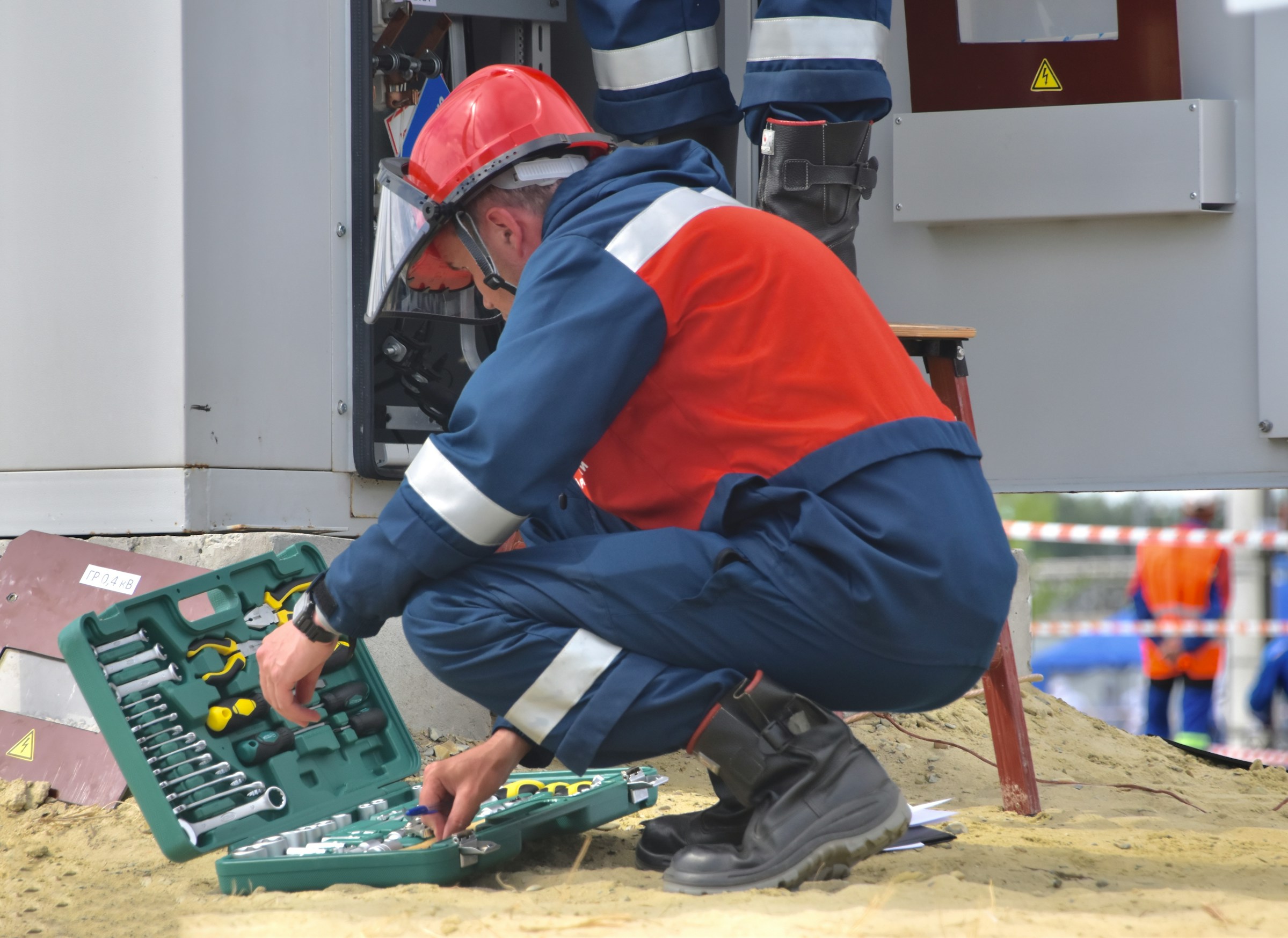An electrician with an overall searching for tools