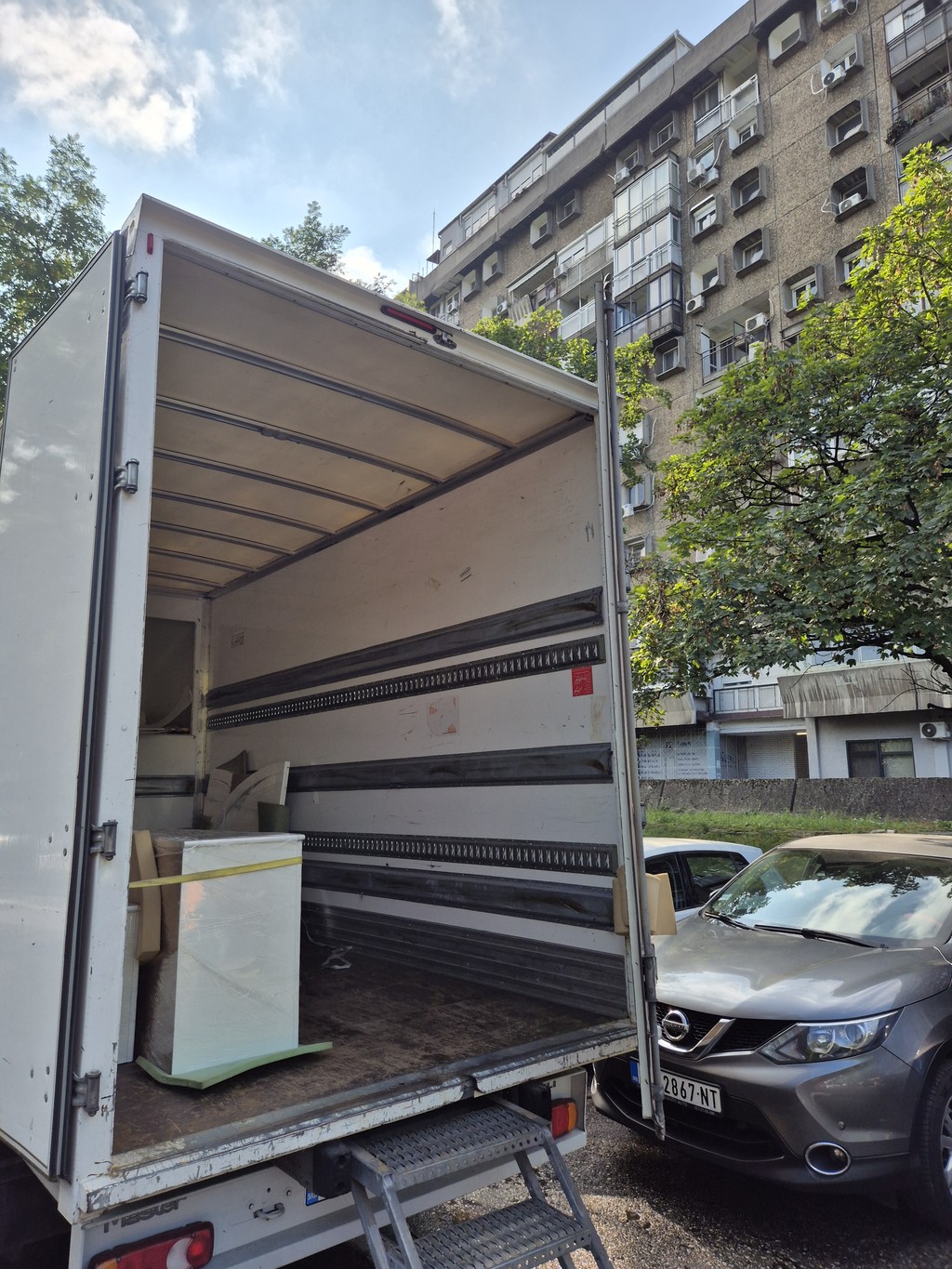 Kamion za selidbe ispred zgrade u Beogradu, utovar nameštaja i kutija