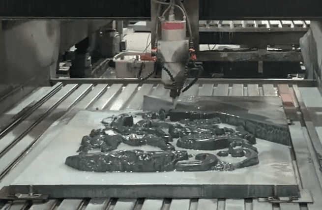 A CNC engraving machine crafting an intricate stone sculpture, revealing detailed three-dimensional patterns.