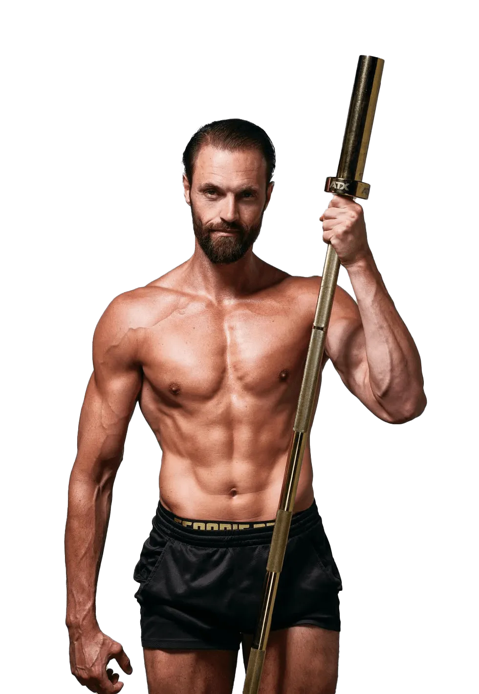 A muscular man holds a gold barbell, wearing black shorts and displaying a confident expression