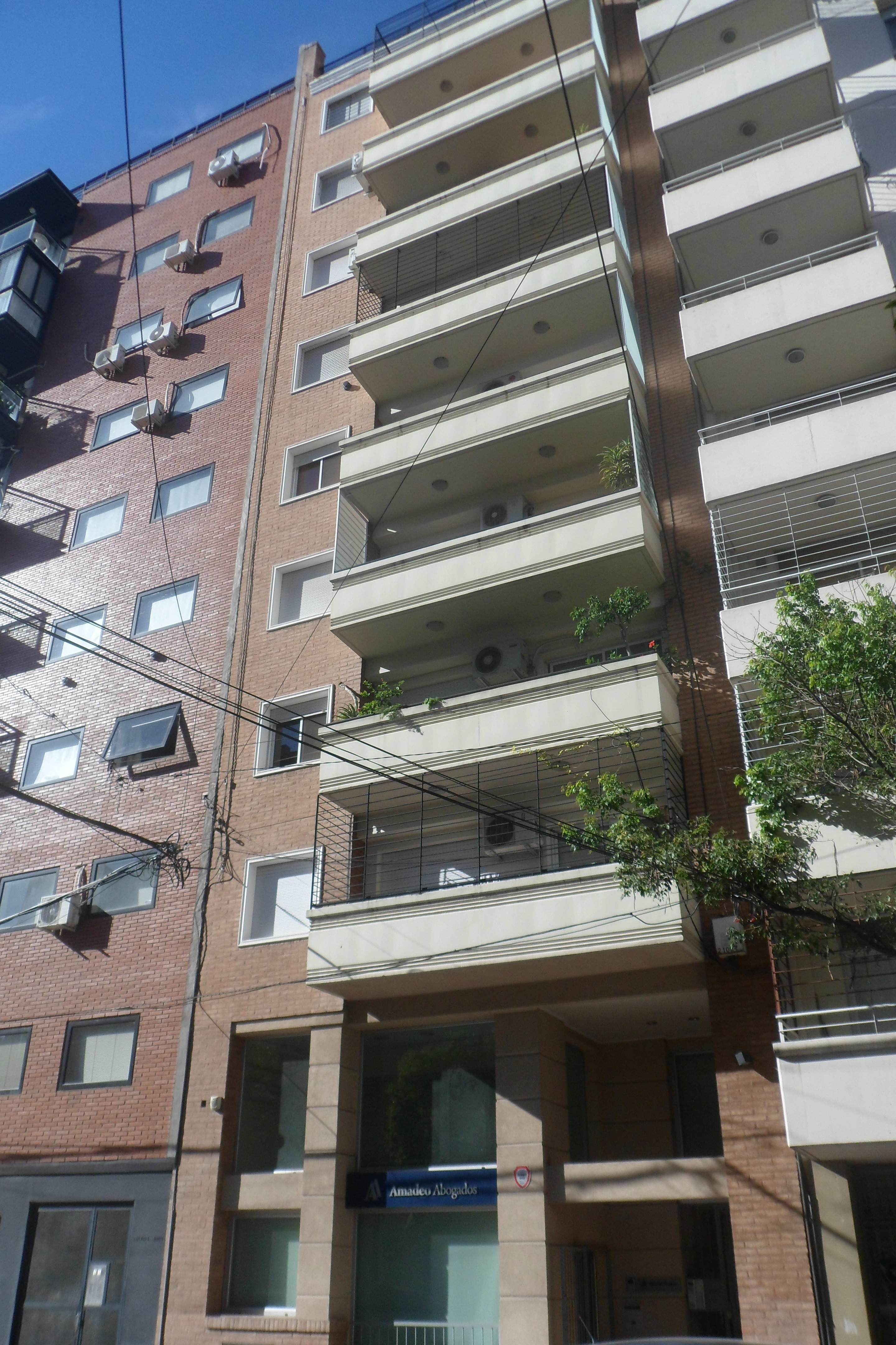 Edificio de departamentos con revestimiento beige, balcones corridos, Edificio Conurban, Rosario