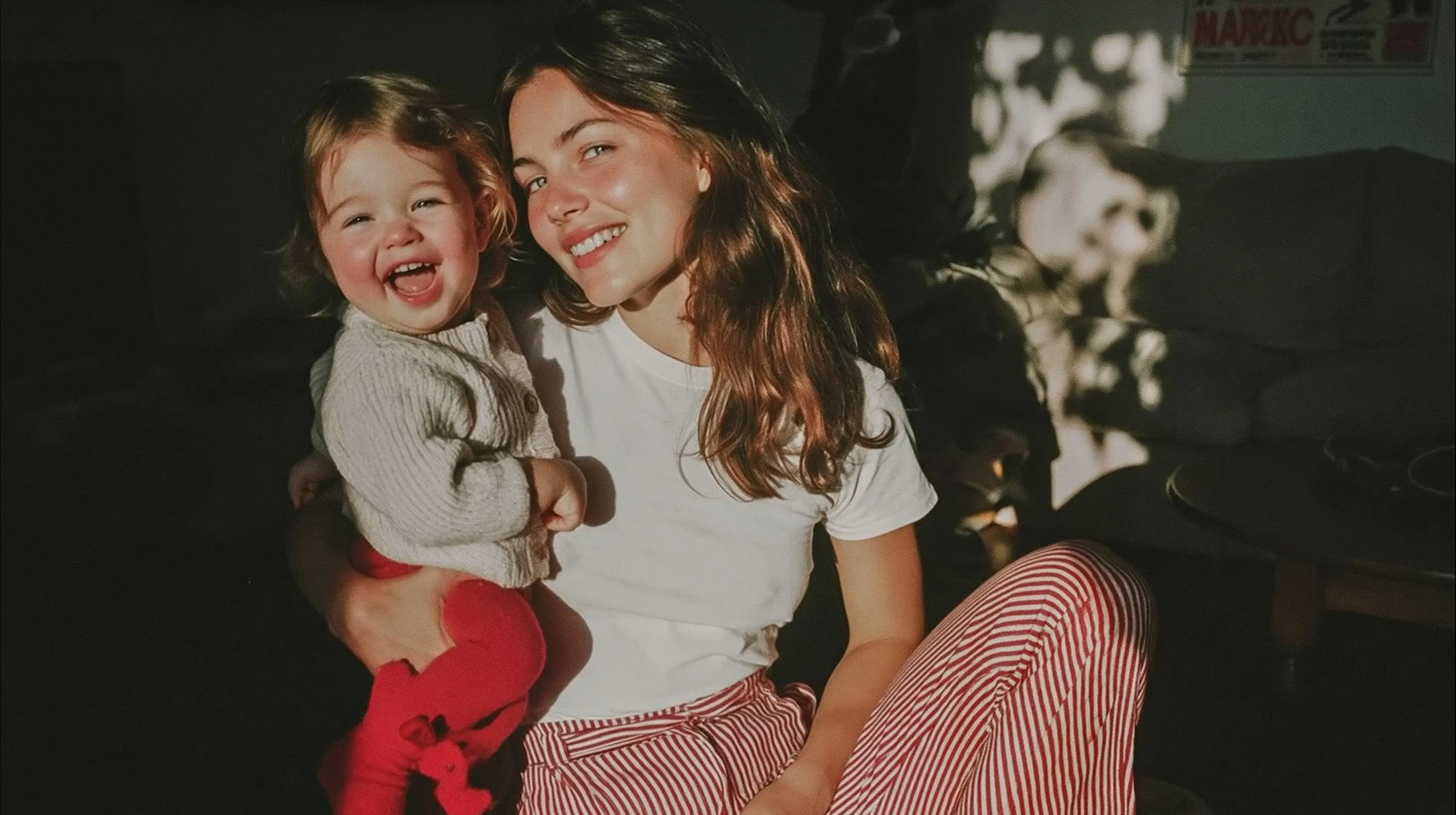 A mother holding her laughing toddler.