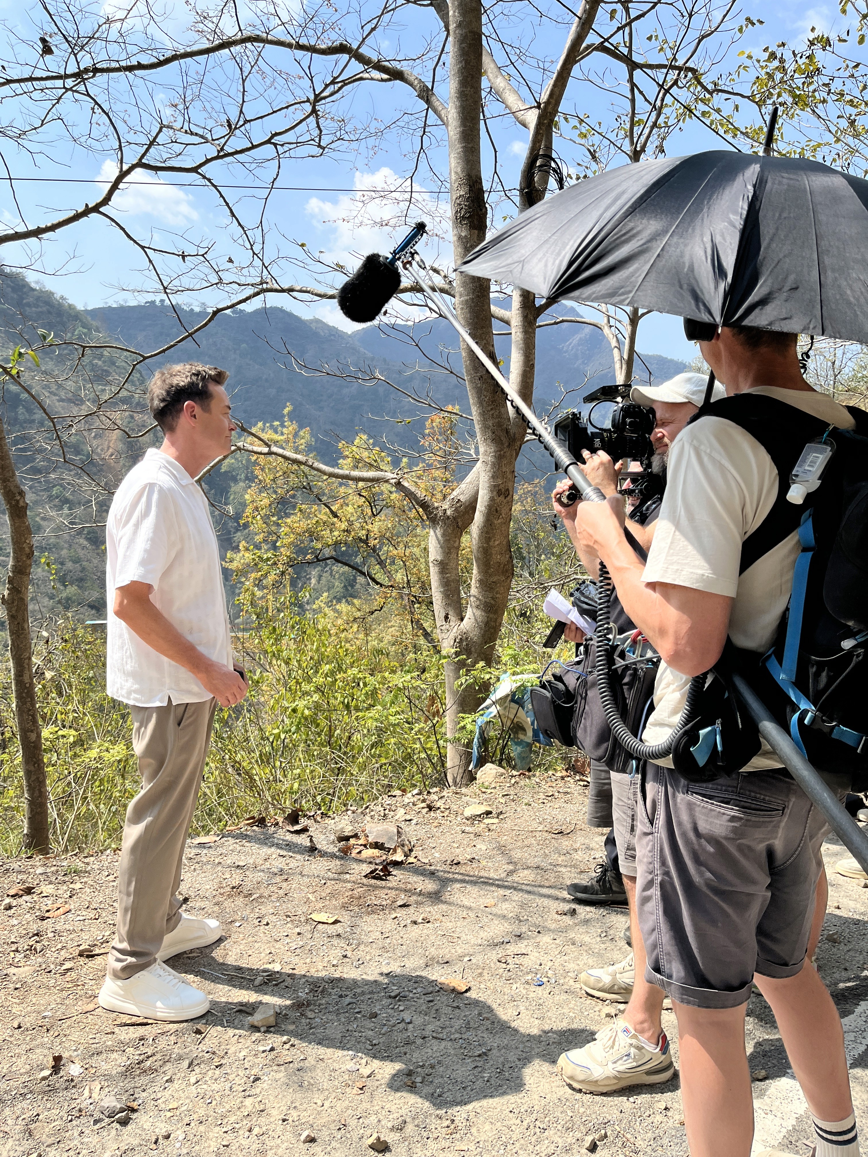 Minimal interior scene with a transparent sofa and a pale cushion against a gray wall.