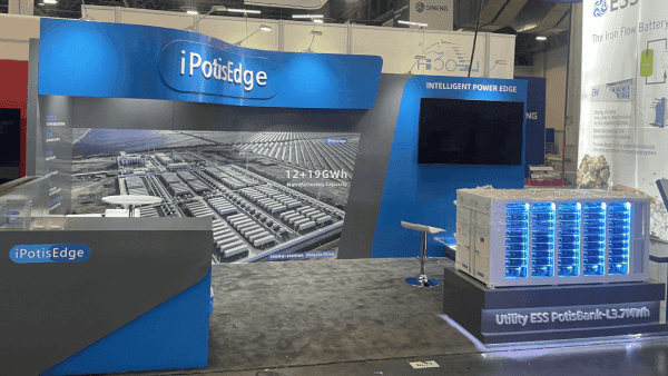 Angled view of a 20x20 RE+ Southeast booth with battery system display, branded wall hierarchy, and buyer-facing counter space