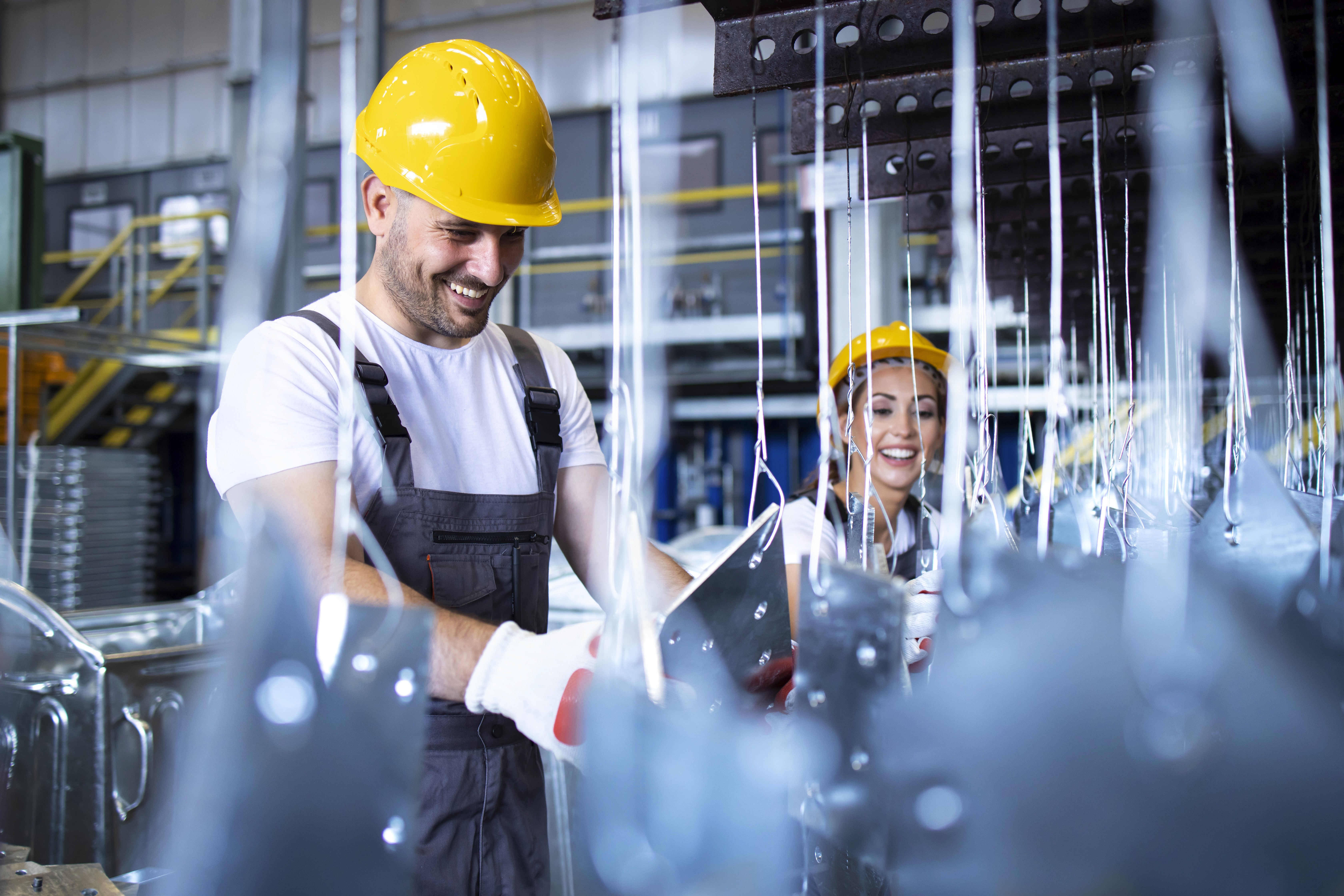Photograph of man sitting, smiling while using a laptop