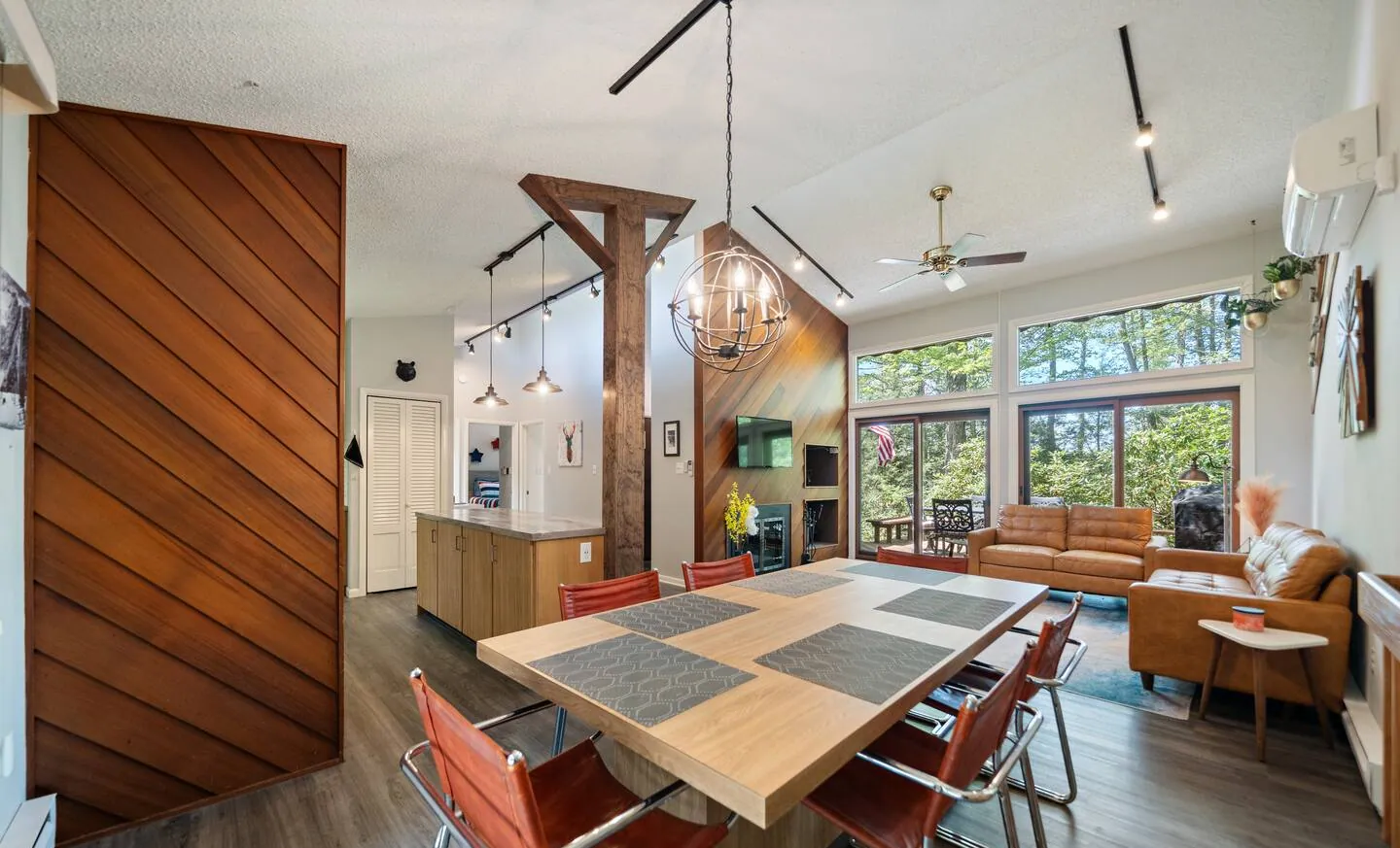 Dining table with orange chairs in the open main level at Lake Front, Lake Naomi