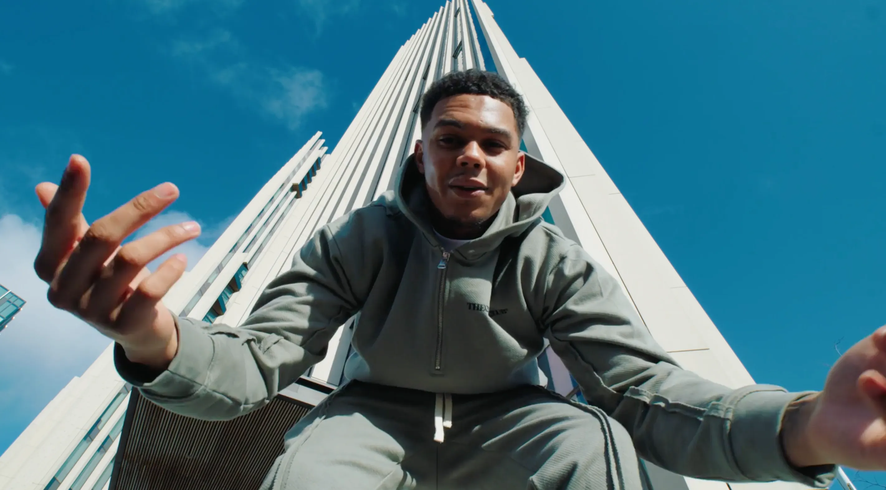 A man stood infront of a tall building in London having his photo taken by X Anima