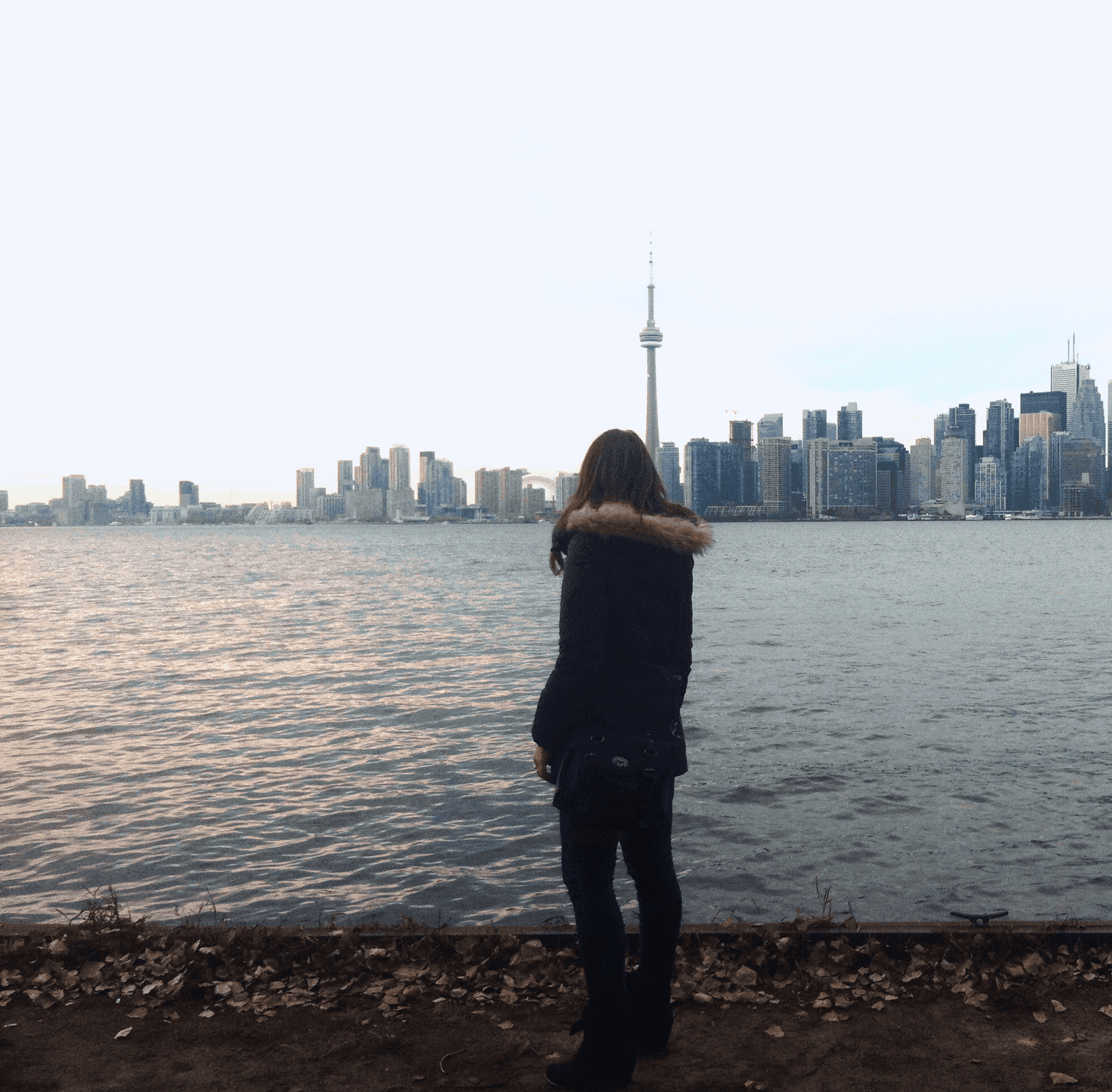 a-woman-looking-at-CNTower-Toronto-bay-skyline