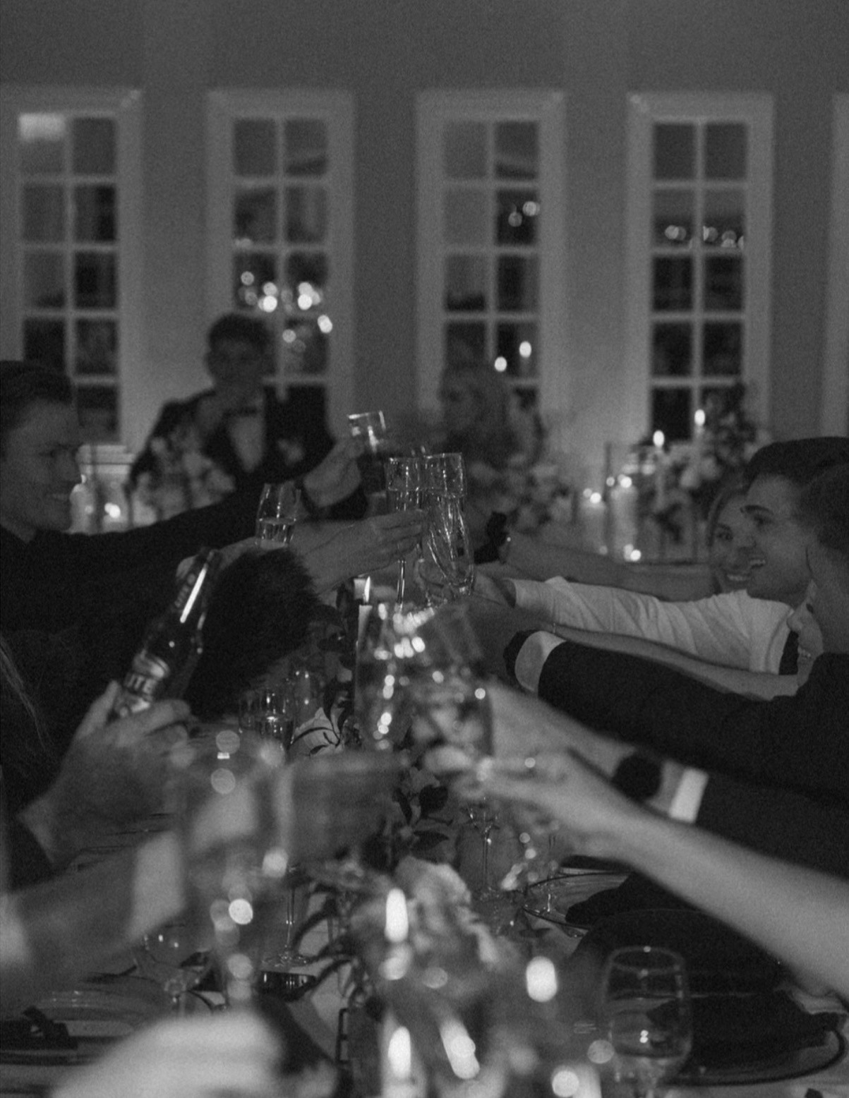 A beautifully set dining table with white tablecloth, cutlery, and fresh greenery in a cozy, well-lit space.