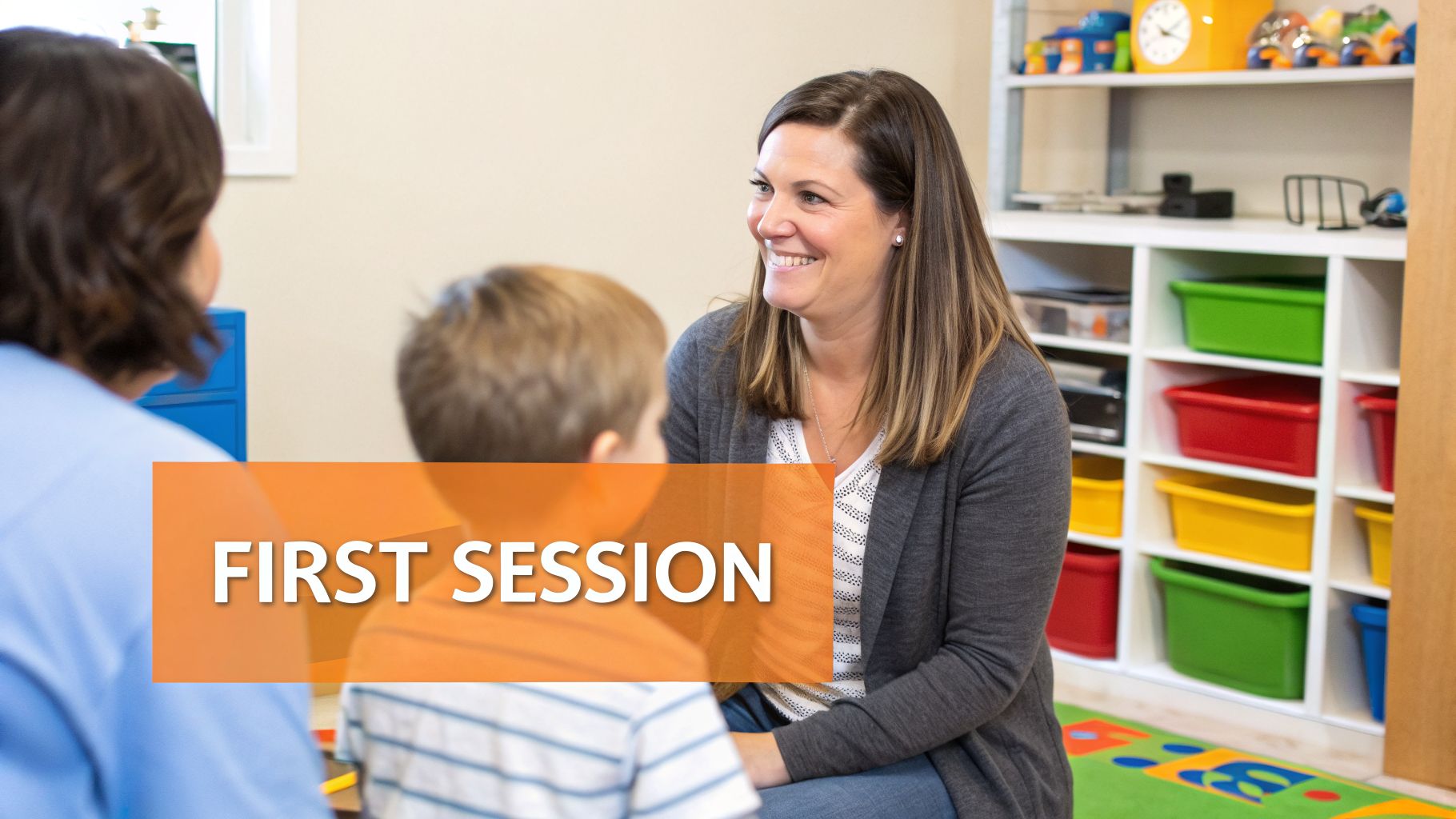 Occupational therapist smiling at a child and parent during a first therapy session.