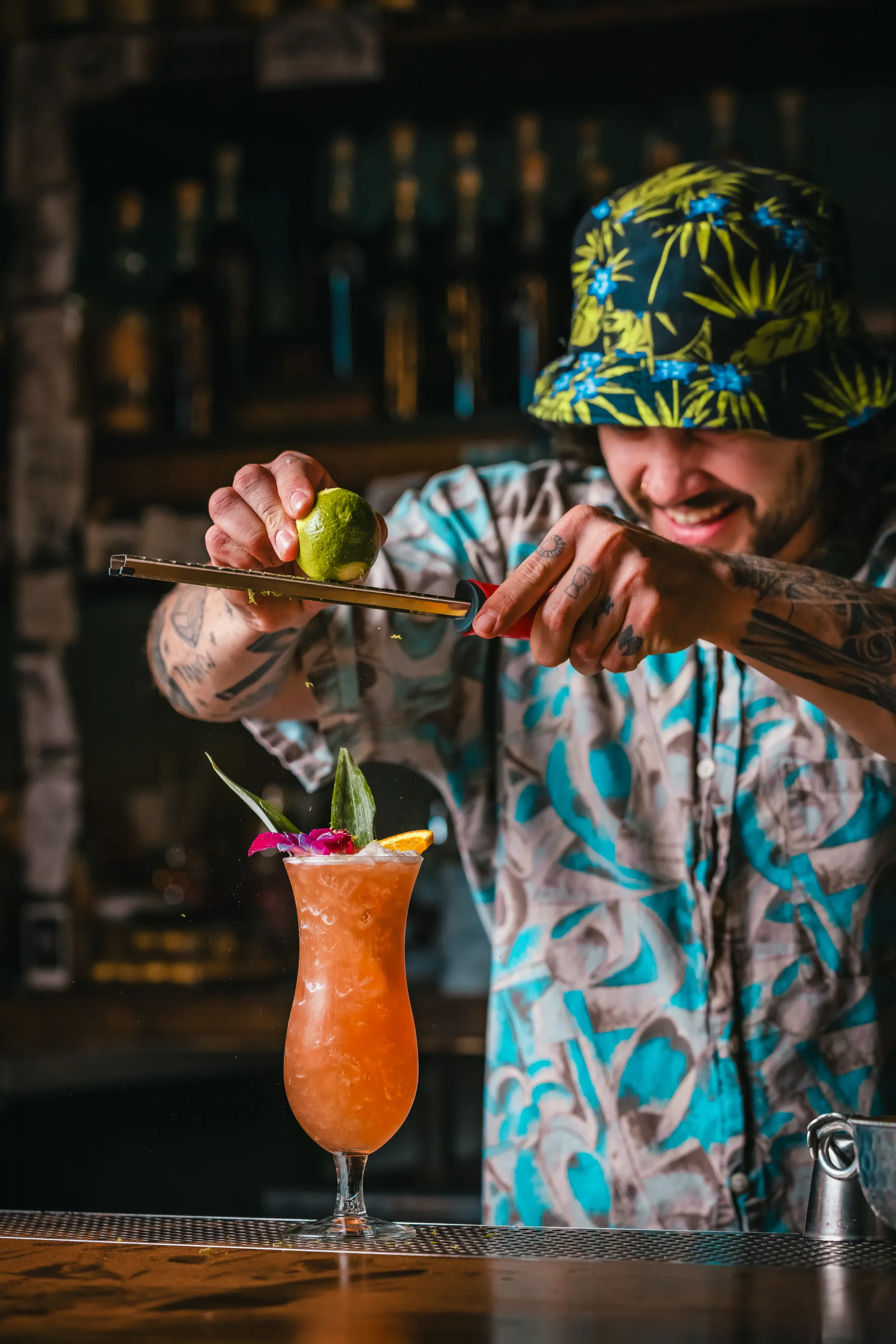 Bartender grating lime zest over a cocktail