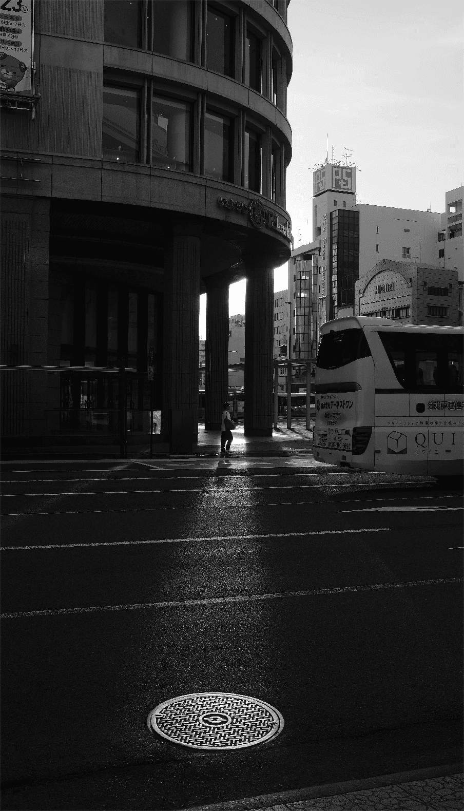 A black and white city scene with a bus.