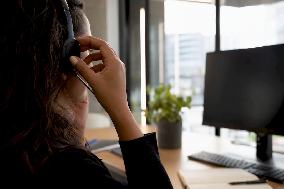 Hands dialing phone headset in marketing office