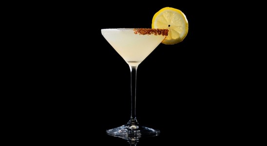 A closeup of a Lemon Drop drink against a dark background.