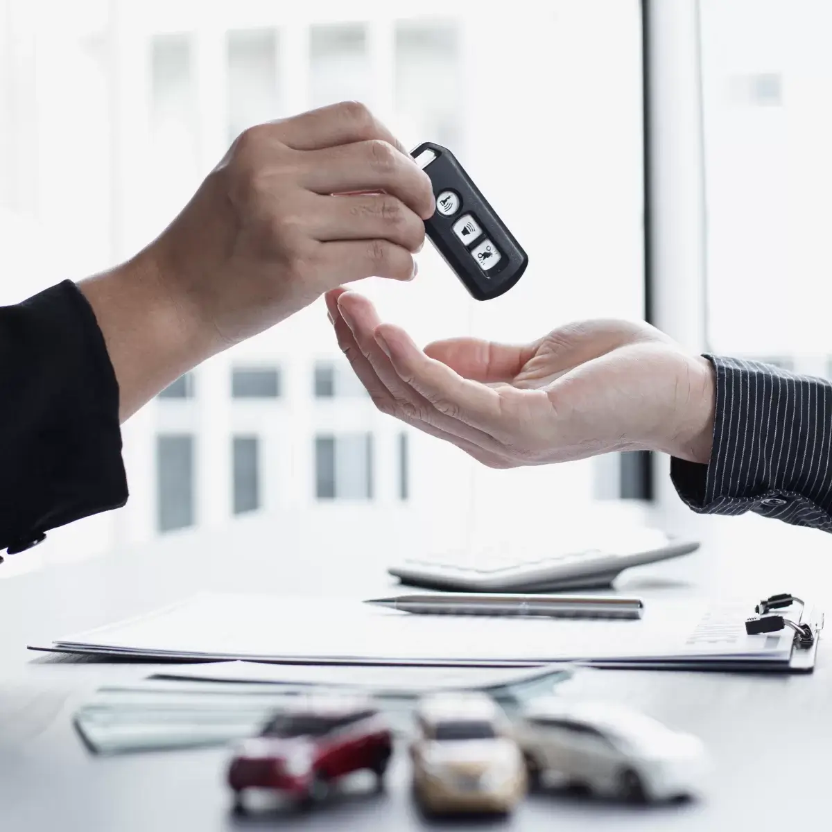 Image of car keys being handed over from one hand to another